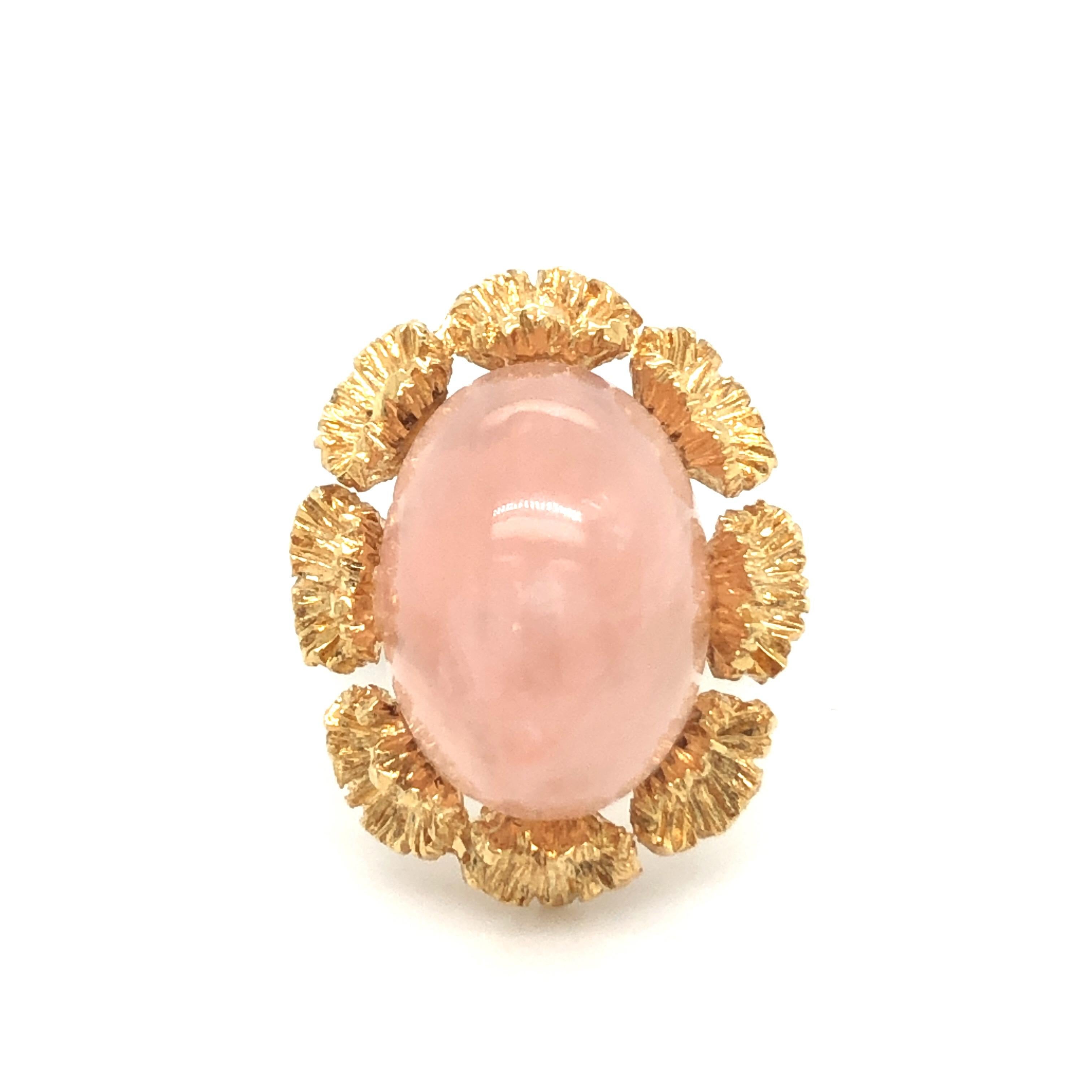 Romantic 18 karat rose gold and rose quartz cocktail ring.
Crafted in 18 karat rose gold and set with an oval pastel rose quartz cabochon of circa 15 carats surrounded by a wreath of structured 18 karat gold flowers.
This jewel is in very good