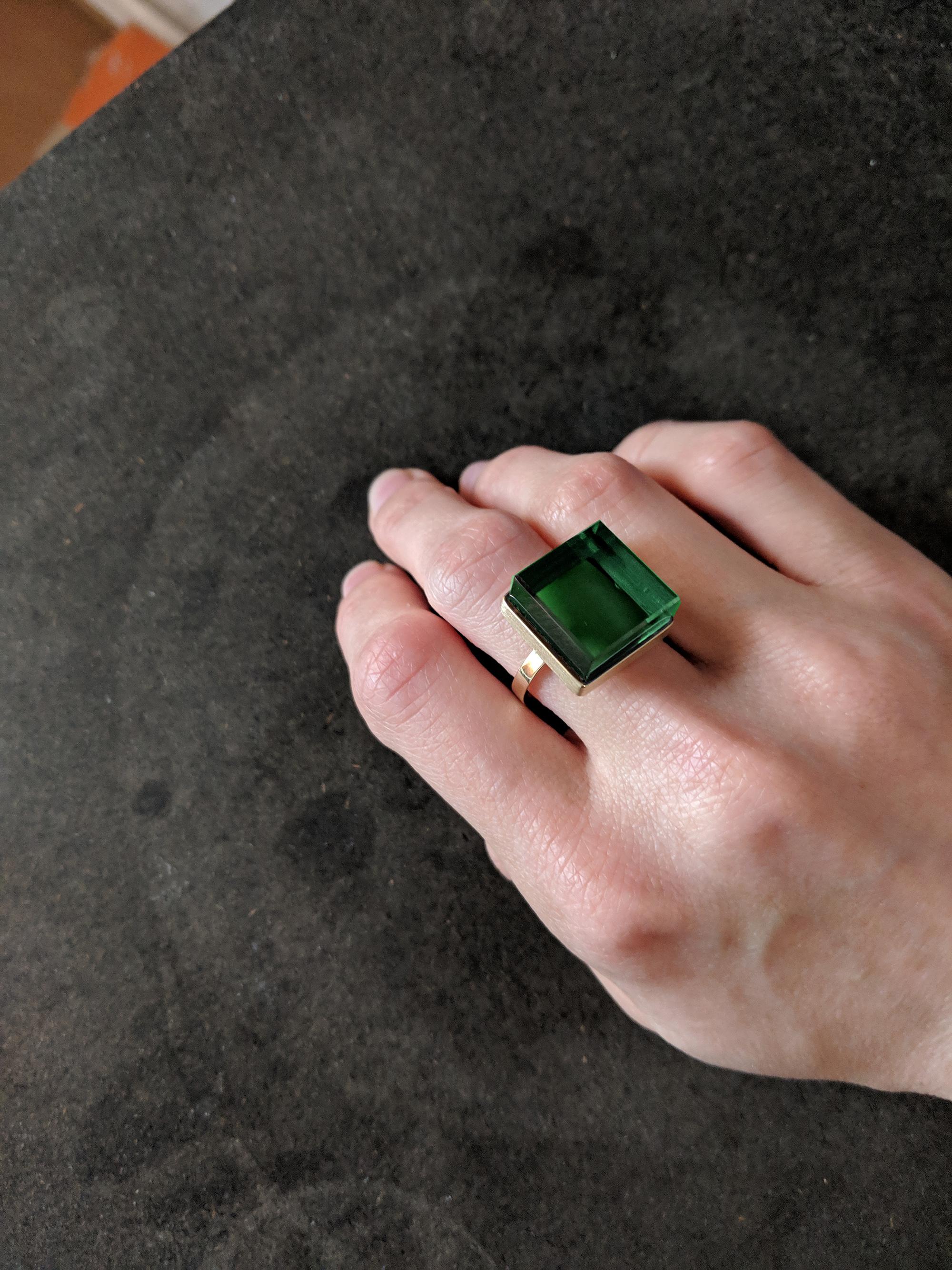 This ring is in 18 Karat rose gold with 15x15x8 mm green grown quartz. The collection was published in Harper's Bazaar and Vogue UA. 

The ring reflects the art deco spirit and fits to women and men. This ring inspires the architects, designers and