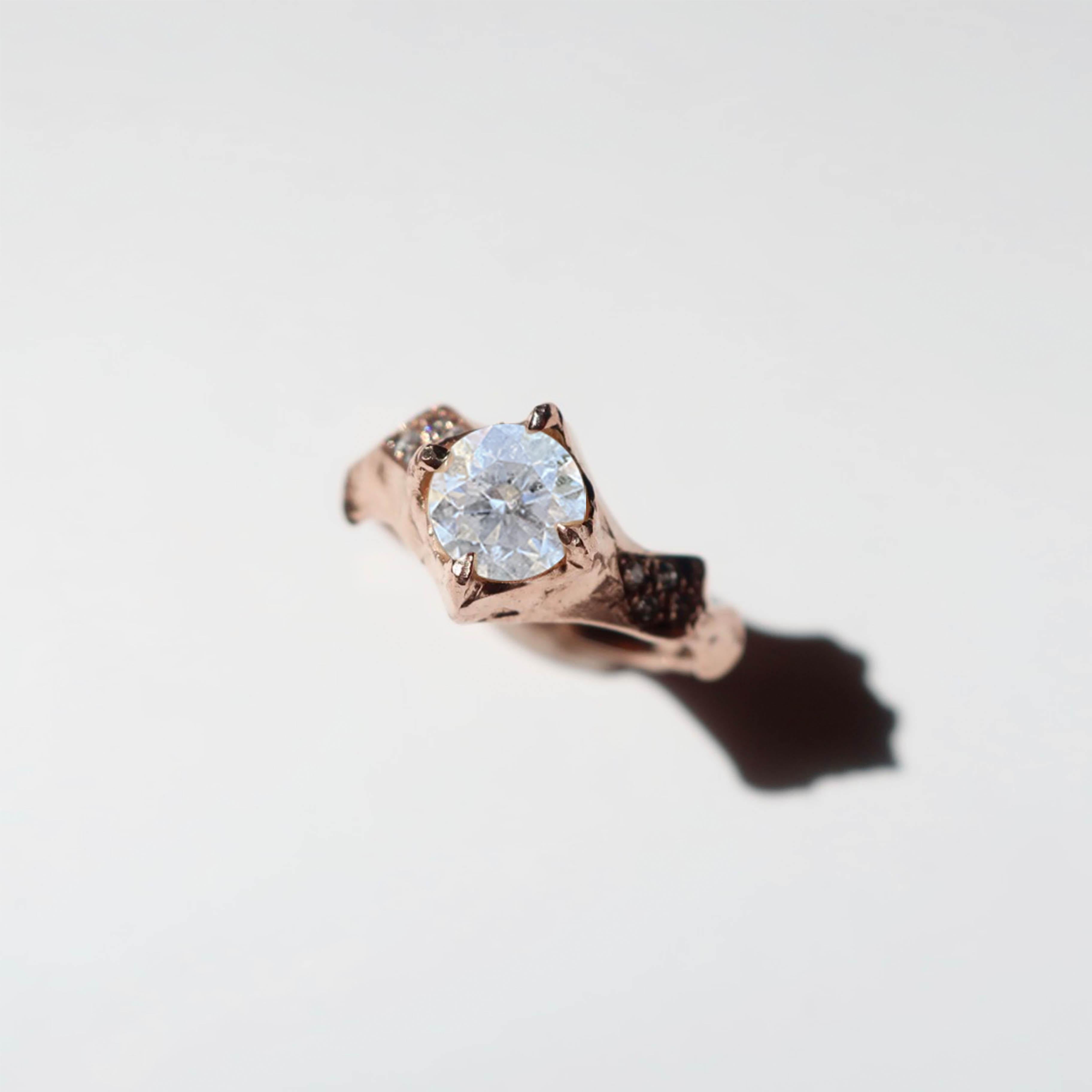 This gorgeous ring is cast in 18k rose gold with a hand selected diamond about 1 carat in weight. A 5.8mm round brilliant cut white diamond is featured in this hand crafted ring with clusters of small vs pave diamonds on the band.



2-4 weeks to