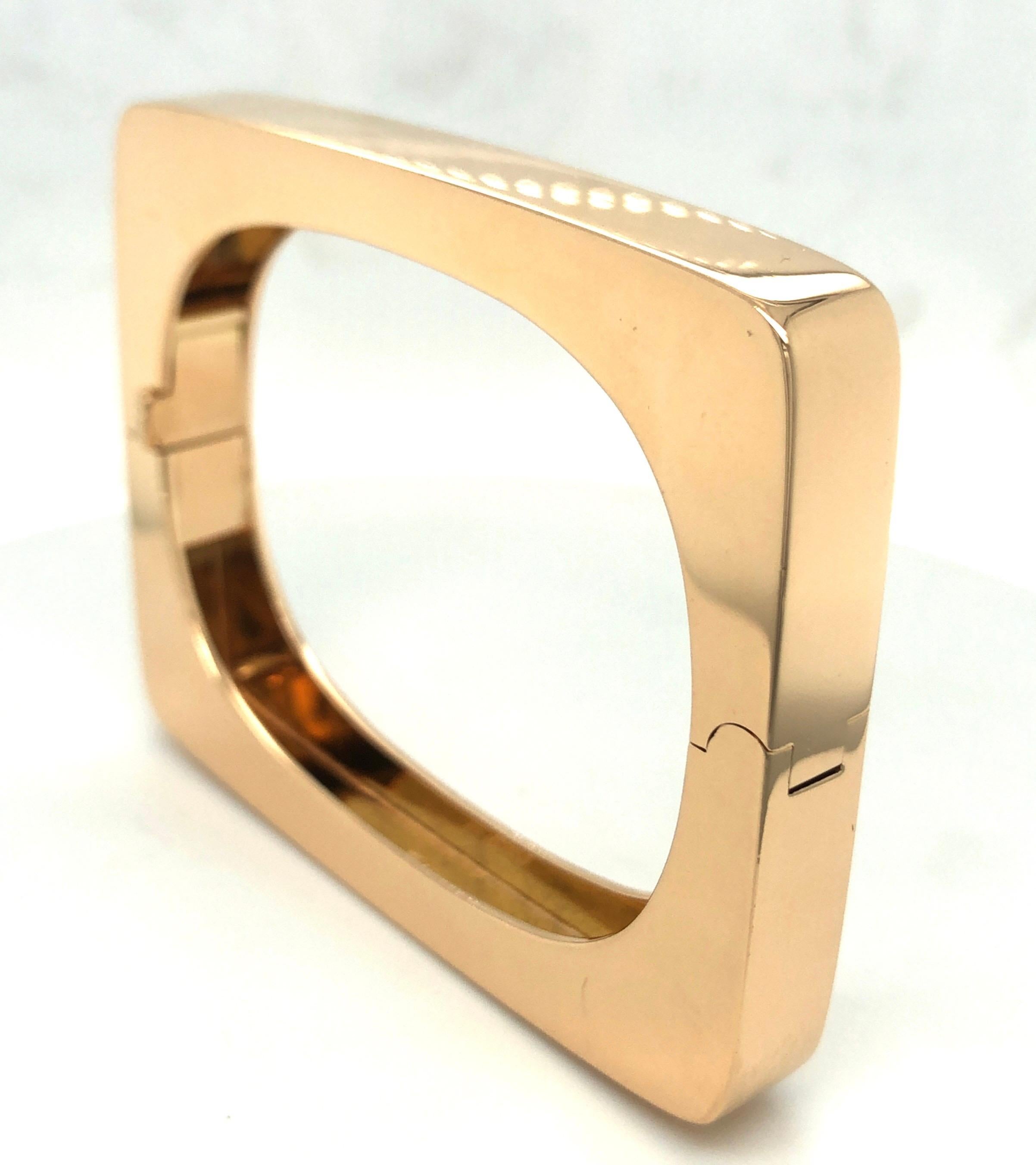 Stylish geometric 18 karat rose gold bangle bracelet by Swiss jeweler Trudel.
Designed as a rectangular outlined bangle with an open oval center. The bangle can be opened by a hinged joint and fastened by a push clasp. A security latch provides