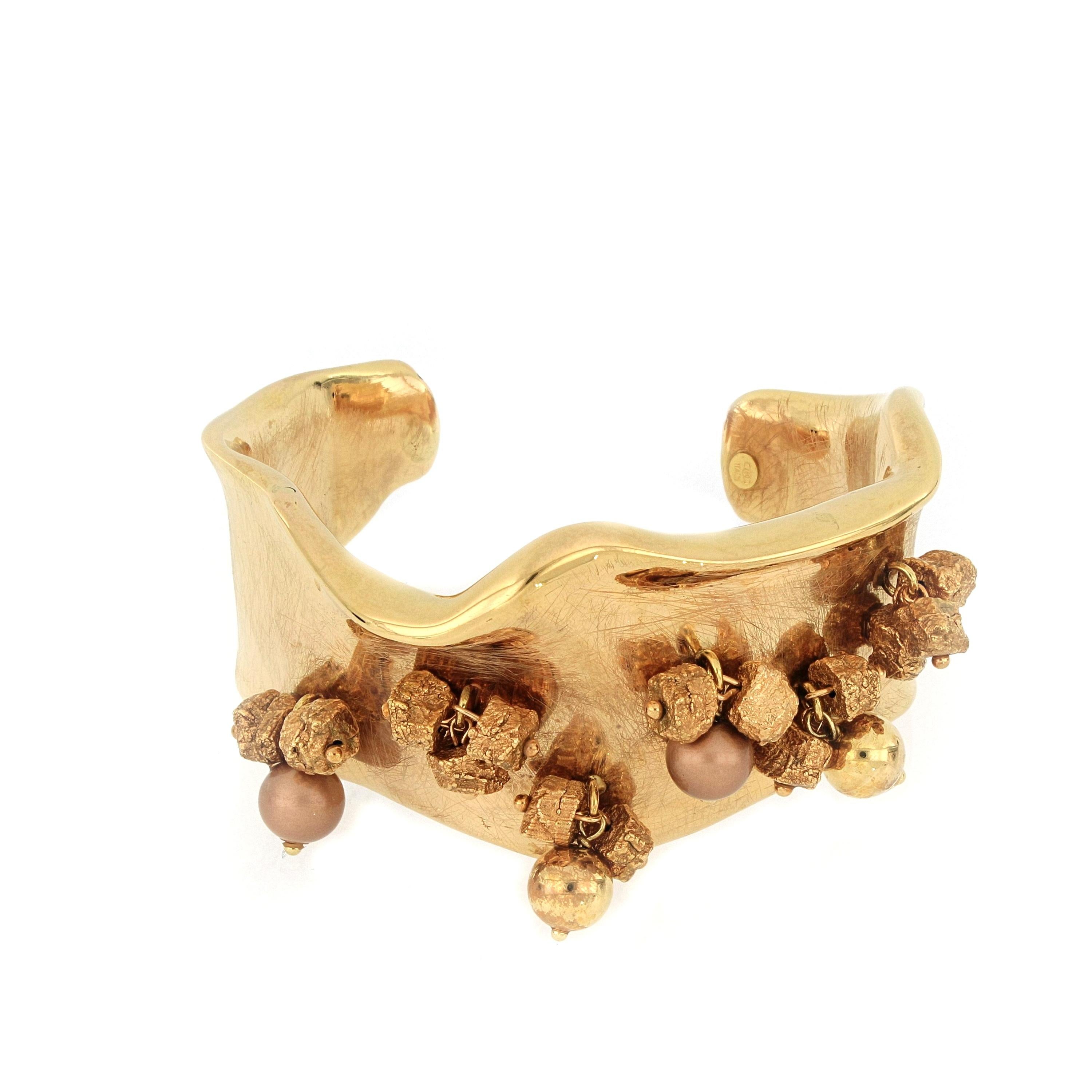 Un bracelet très unique en or rose 18 carats, brossé et dépoli  avec un savoir-faire italien. Les bracelets sont suspendus avec des pièces d'or de différentes formes, élégantes et stylées.
O'Che 1867 est née il y a un siècle et demi à Macao. La