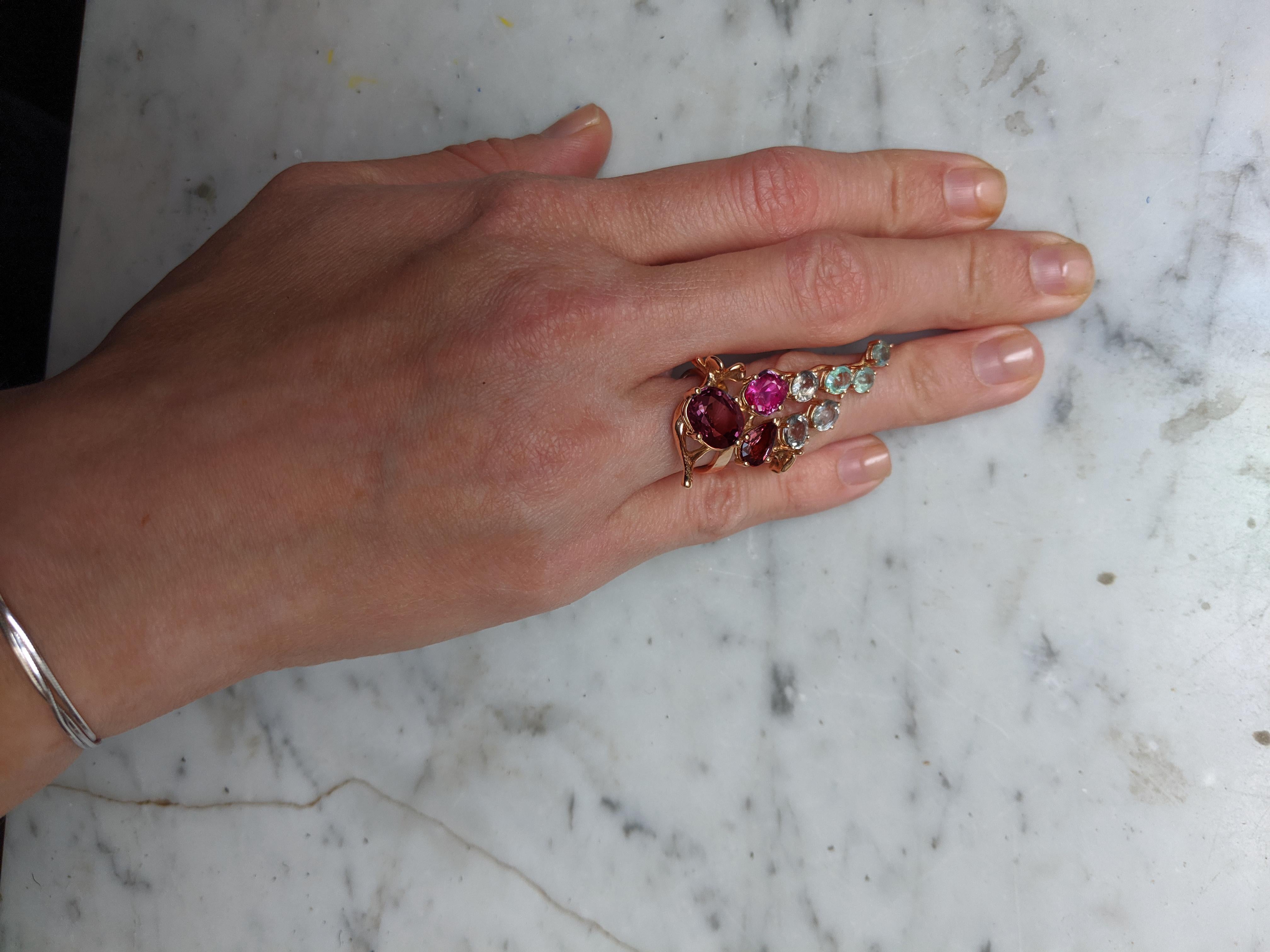 This Tobacco Flower cocktail ring is made of 18 karat rose gold and features a stunning array of natural gems including:

Oval ruby 4.27 carats, dimensions: 11.16x9.36 mm
Oval ruby 0.98 carats, 7x5.5 mm
Oval ruby with a warmer tone, 1.01 carats,