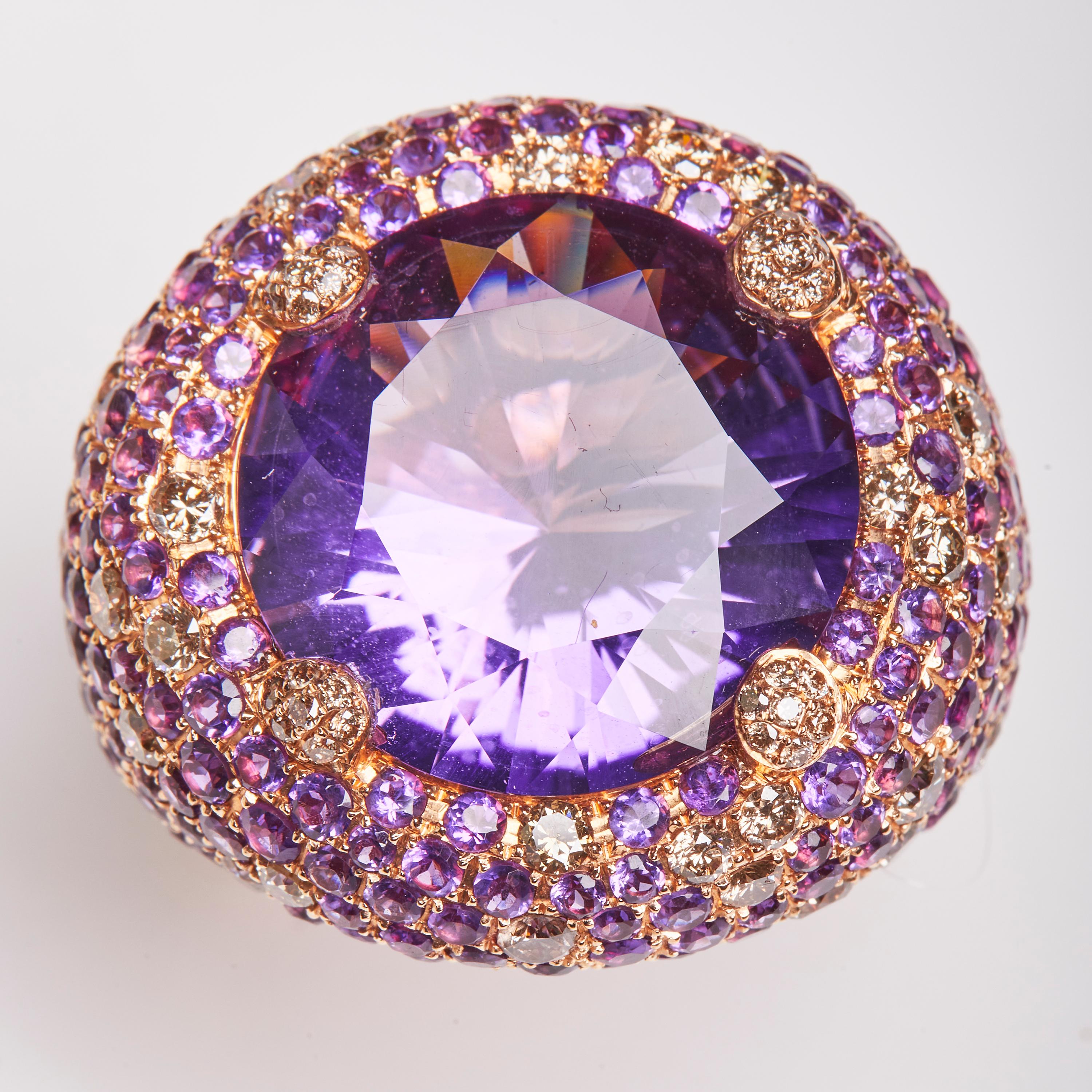 This 18 Karat Rose Gold ring is embellished with elegant Cognac colored Diamonds and a dazzling round cut Amethyst center stone. This ring is a  perfect compliment to our matching Rose Gold, Diamond, Tsavorite and Amethyst Chain and pendant and