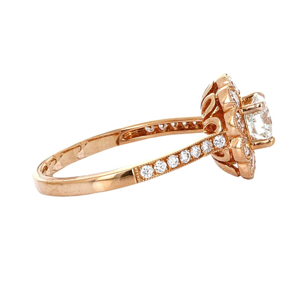 18 karat rose gold diamond bridal ring with a 0.71 carat round brilliant diamond center.
There are 10 smaller round brilliant diamonds surrounding the center stone with pave diamonds down the shank/ band. 
The ring has a total of 1.34 carats in