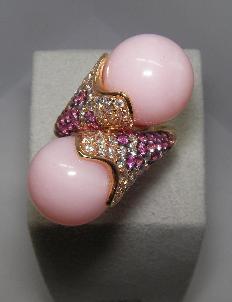 This Rose Gold cocktail ring is adorned with White Diamonds and Pink Sapphires and highlights two graceful spherical Rose colored Opal stones. Fine craftsmanship and elegant details are the highlights of this conversation piece.


54 Diamonds 0.98