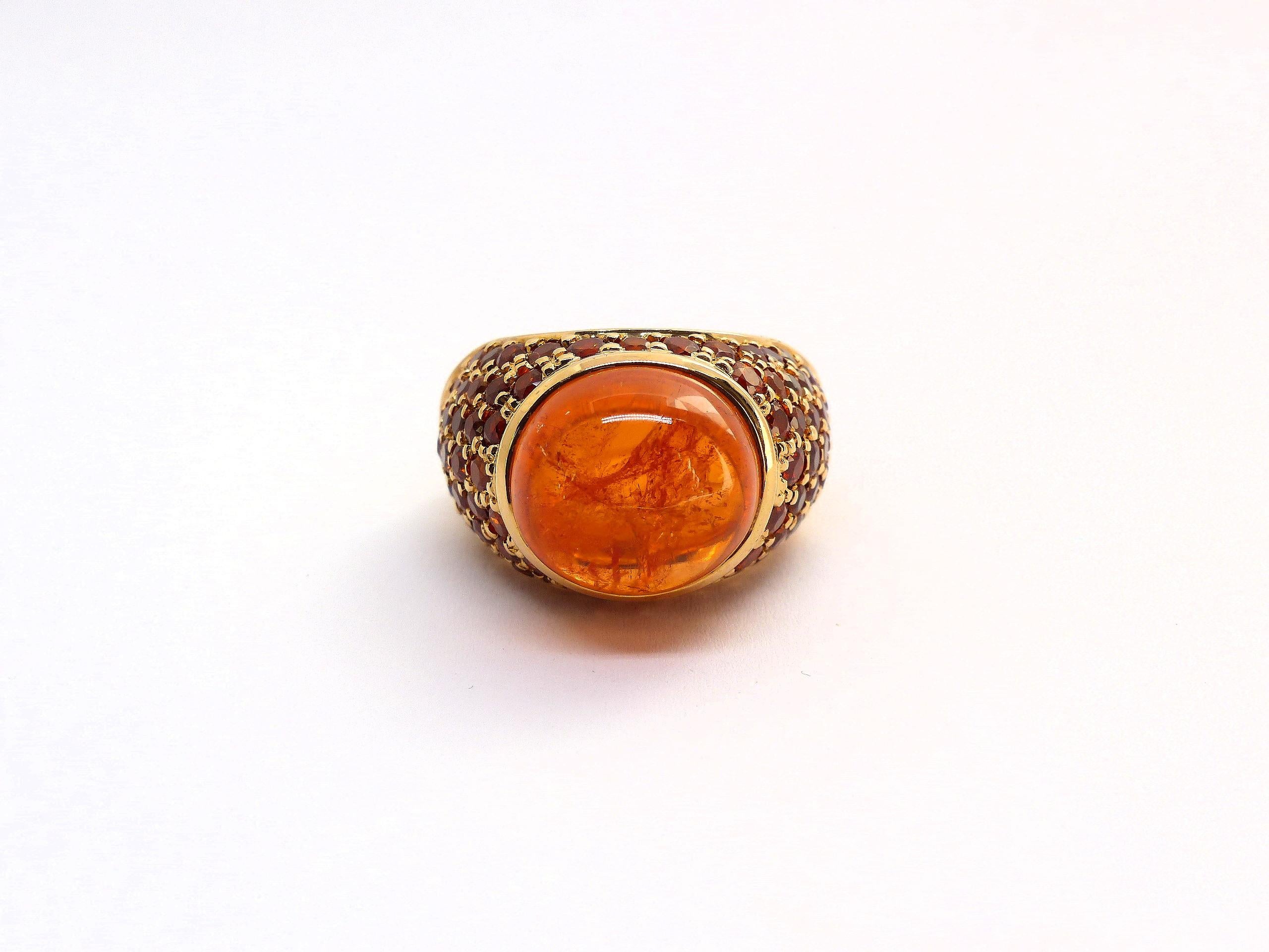 Dieser Ring aus 18k Roségold (23,20g) ist mit 1x feinem Mandarin-Granat Cabouchon (oval, 14,5x13,5mm, 18,47cts) besetzt. + 72x Mandarin-Granaten (facettiert, rund, 2-3 mm, 5,97cts). 

Ringgröße: 6 3/4 (53.5)