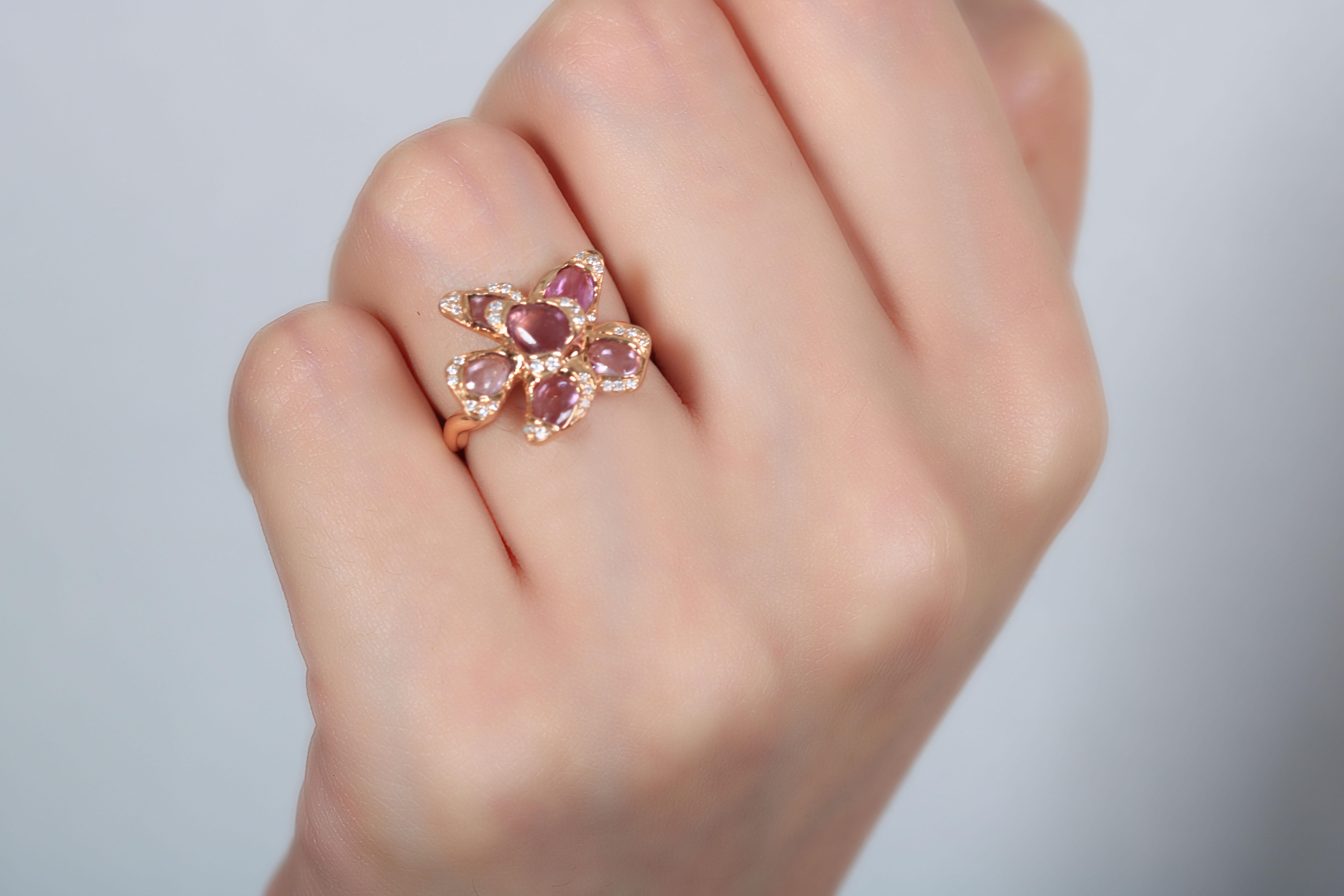 An elegant sapphire ring with a dramatic centerpiece comprised of the finest pink sapphires and white diamonds. The placement of the sapphires and diamonds is breathtaking and intertwined to make the ultimate impact. With a subtle extravagance, this