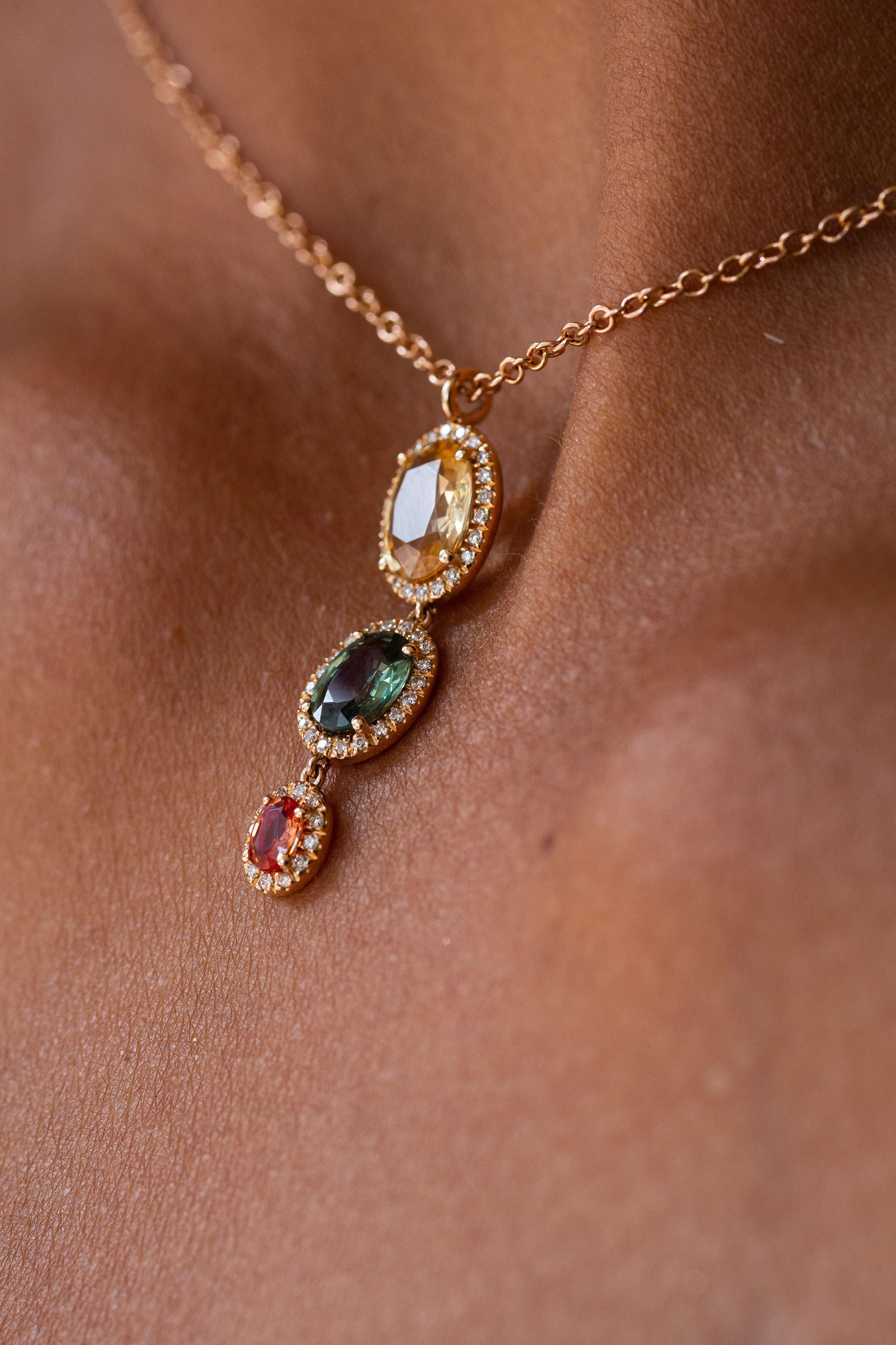 Anhänger aus 18 Karat Roségold stammt aus der Riad-Kollektion. Diese schöne Halskette besteht aus 3 ovalen, mehrfarbigen Saphiren von insgesamt 2,33 Karat und weißen Diamanten von insgesamt 0,16 Karat. Das Gesamtgewicht des Metalls beträgt 4,40 g.