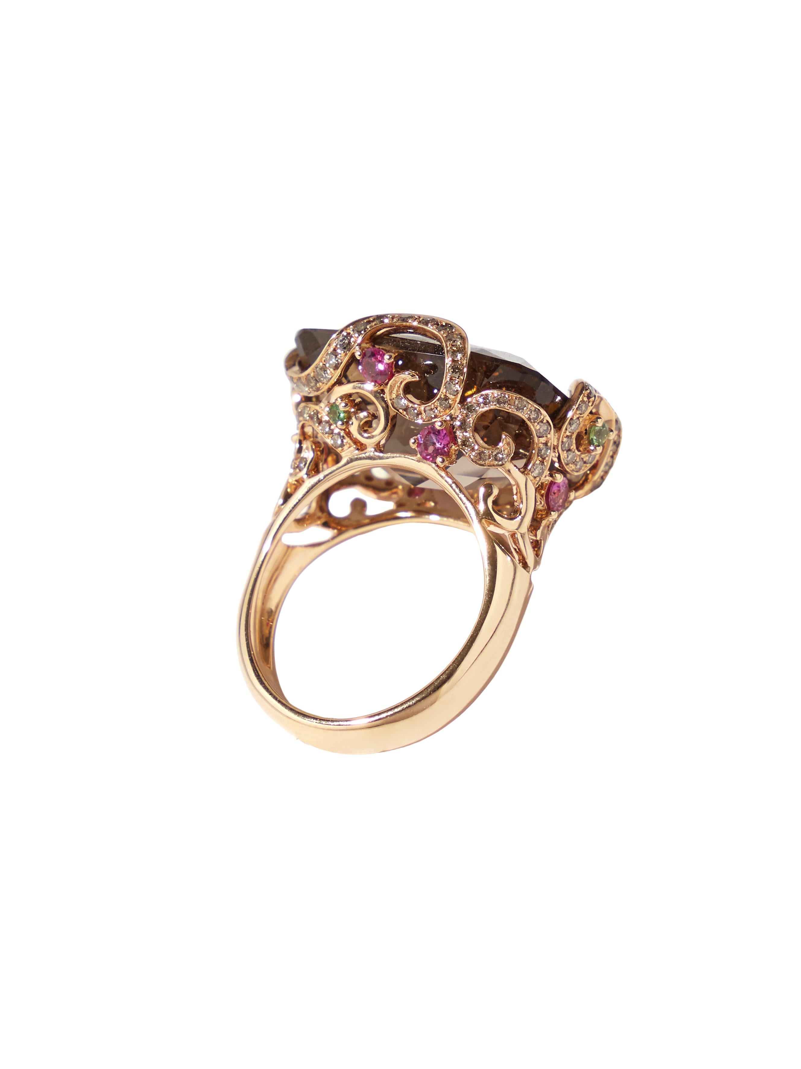 This Bonebakker ring is made in 18 karat rose gold featuring a 21 mm x 15.5 mm cushion checkerboard cut smokey quartz, pink and orange sapphires and 0.20 ct of champagne diamonds. 

The setting holding the warm smokey quartz is crafted in rose gold