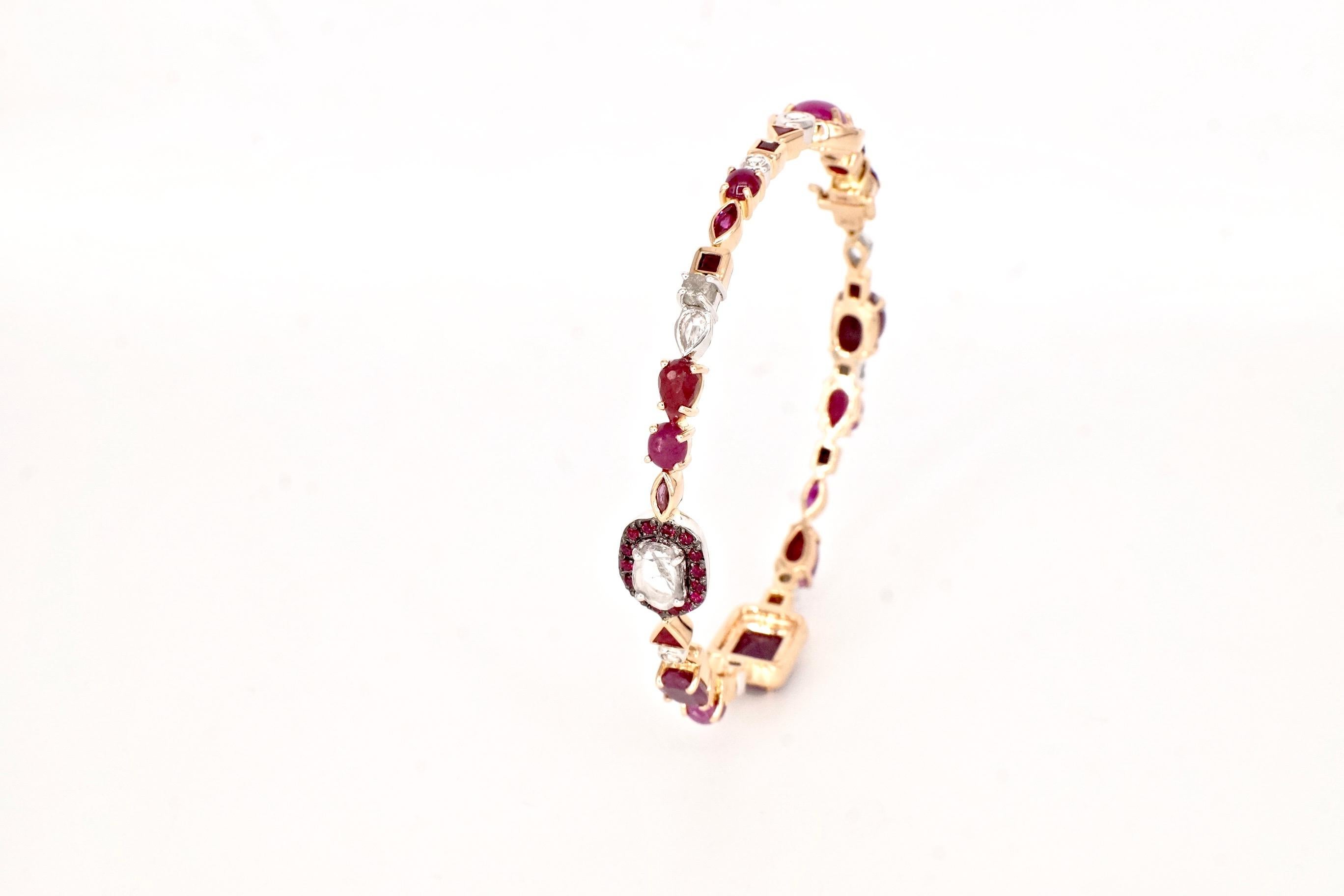 Ruby Baby Bangle 
An eighteen-karat rose gold hinged bangle set entirely with white diamonds and rubies in a variety of shapes and sizes
Diamond Total Weight – 1.69 cts.
Gemstone Total Weight – 18.36 cts.
This piece is one-of-a-kind and entirely