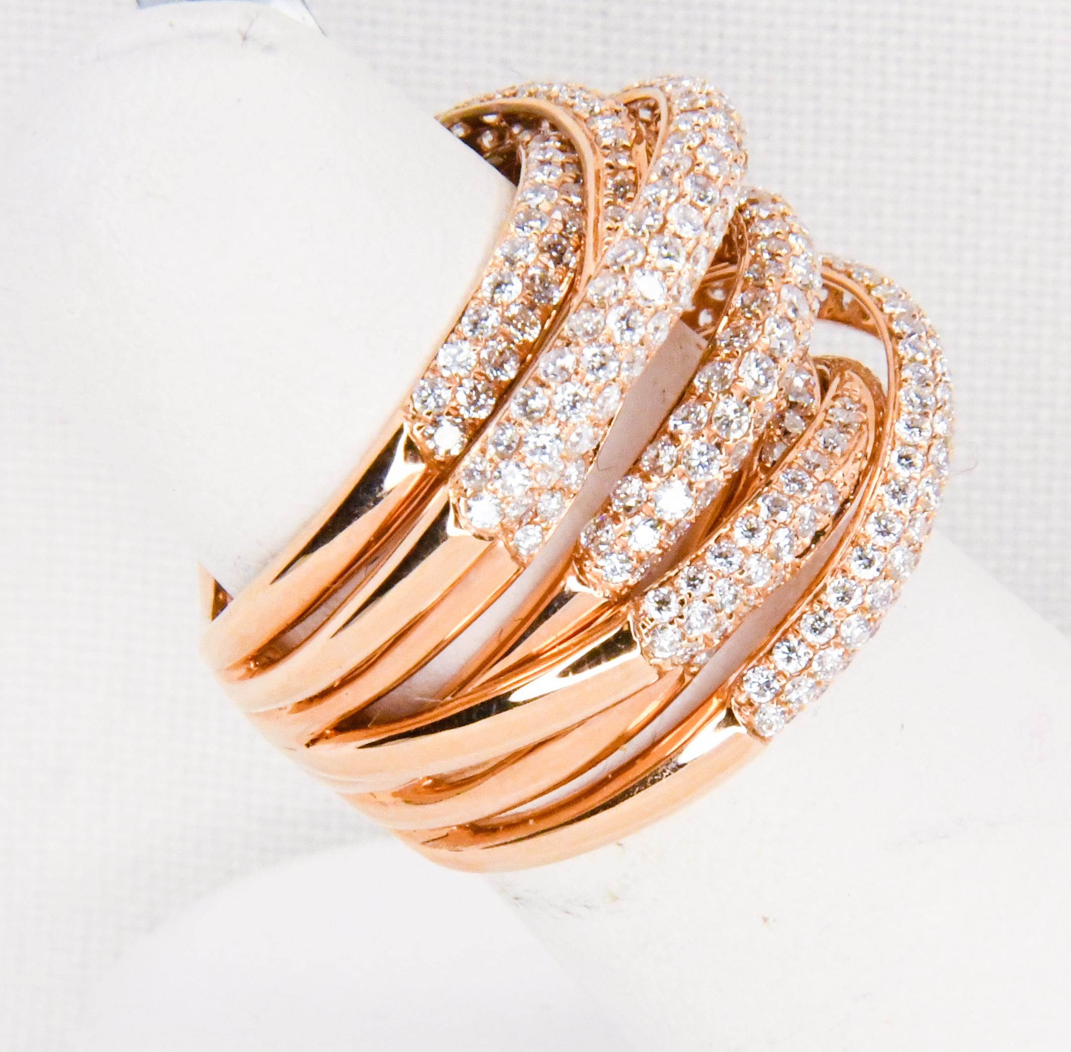 Never worn.  Brand new!  Artfully fabricated in 18 karat rose gold this ring is an absolute stunner!  Seven rows encrusted in micro pave white diamonds are gracefully arched at different levels.  Center row goes straight across while each end of