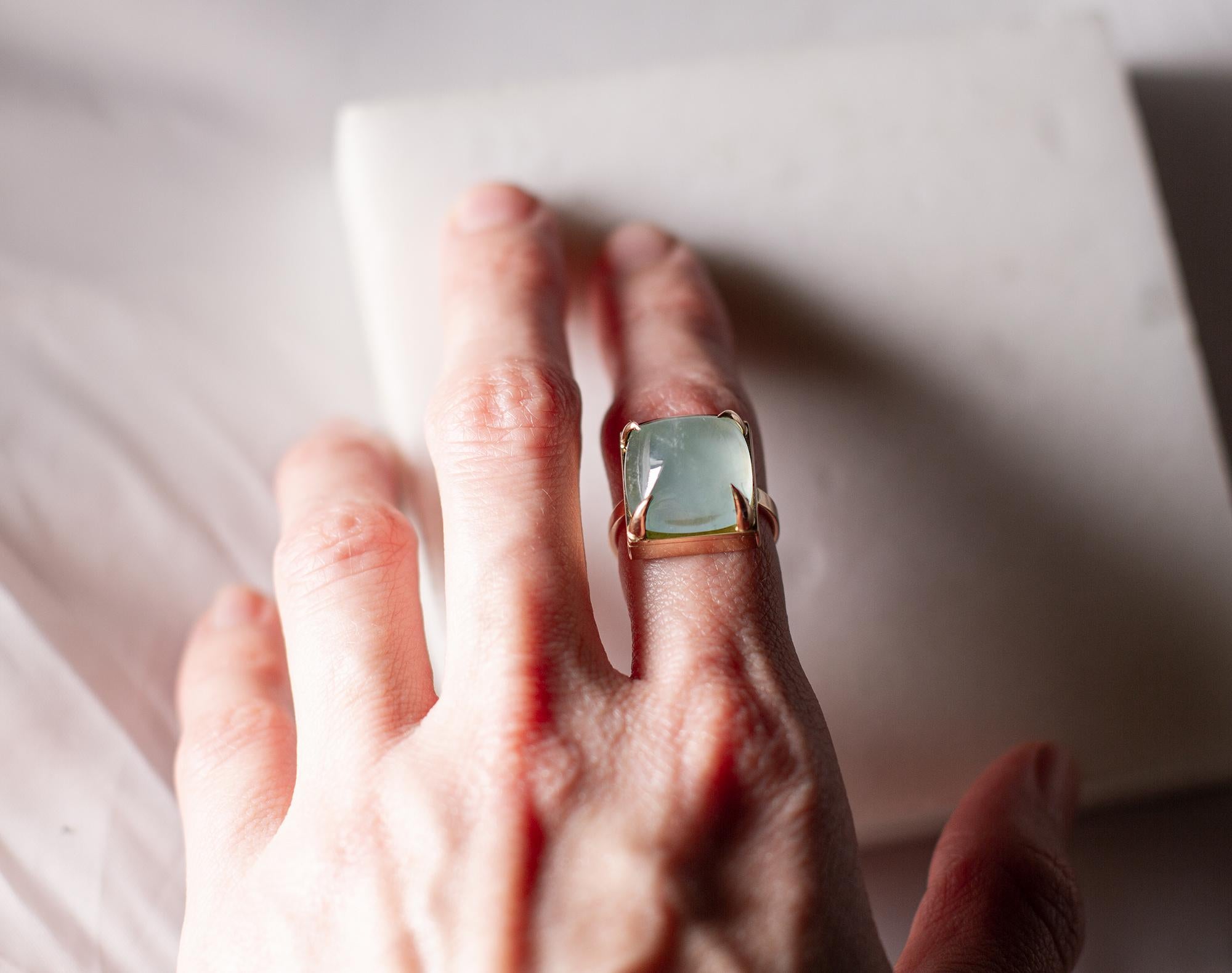 This ring is made of 18 karat rose gold with sugarloaf cut natural aquamarine. 

When for most of the gem it works the way: the smaller prongs the better. This is the shape and size of the gem that we really enjoy to see avoiding the typical for