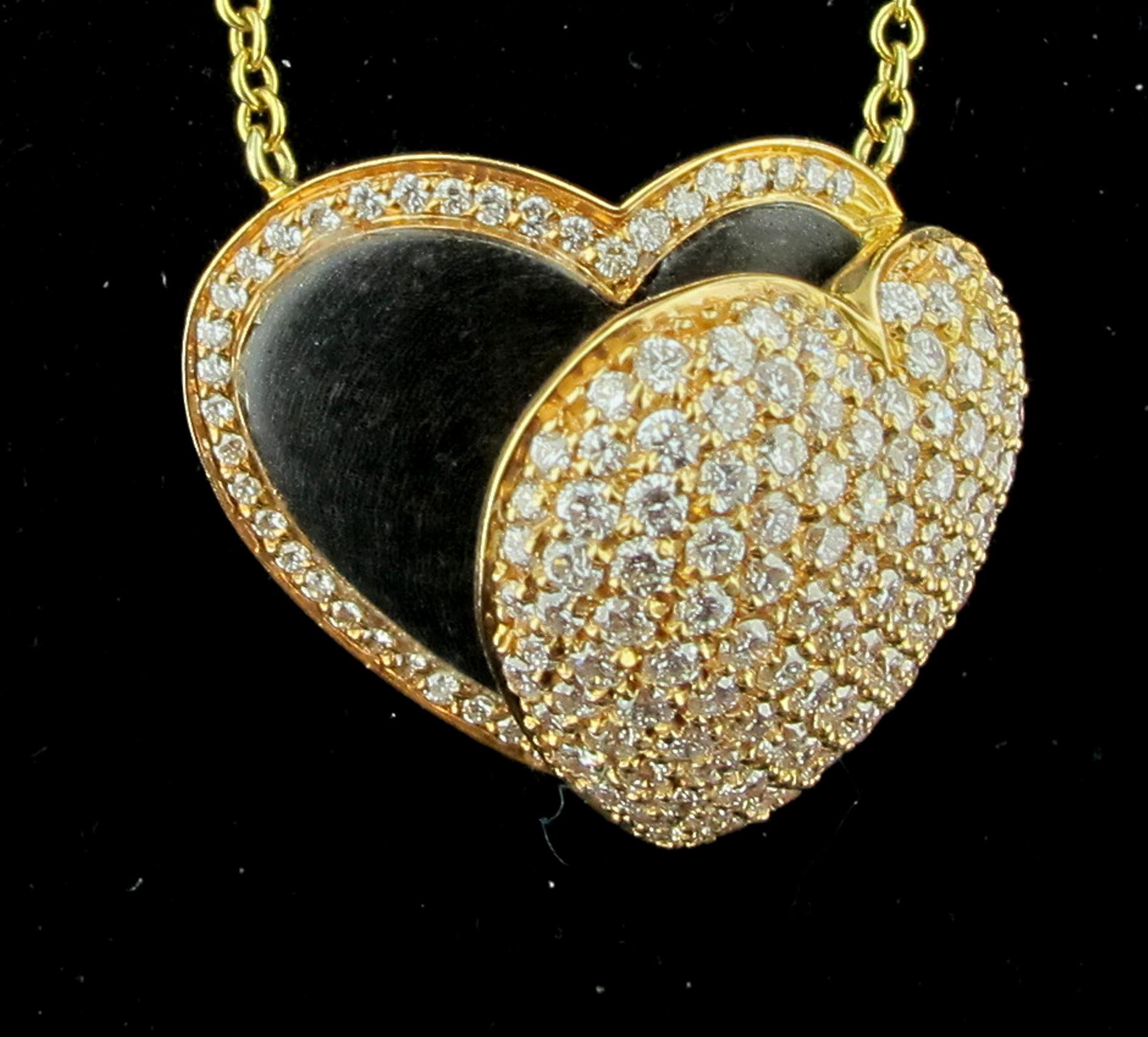 Set in 18 karat rose & yellow gold is a heart pendant with 180 round brilliant cut diamonds.  The open center is made of wood.  The total diamond weight is 1.85 carats G color, VS clarity. 17 grams of gold.