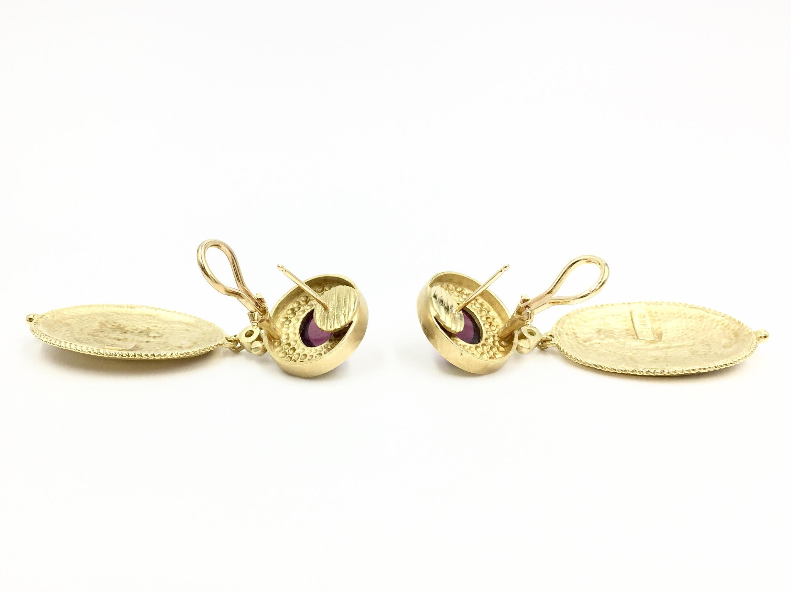 Solid and substantial 18 karat yellow gold Greek Revival drop earrings made with superior craftsmanship by Seidengang. These gorgeous earrings have an exquisite finish, hand carved Greek goddess and feature a smooth cabochon pinkish-red rubelite and