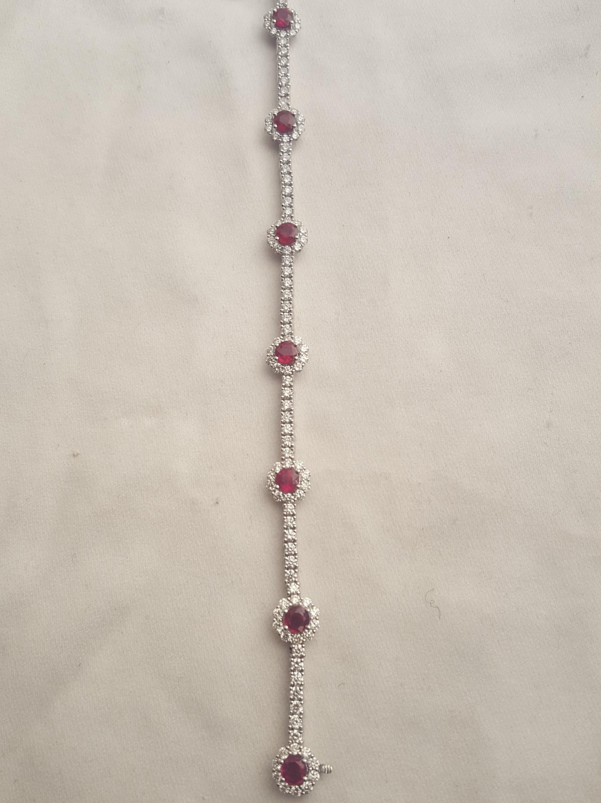 Brand new and Never worn!  Meticulously crafted in 18 karat white gold, this inline bracelet is a stand out!  Combining rubies and diamonds always creates an eye popping fashion statement!  Seven stations boast round perfectly matched faceted rubies