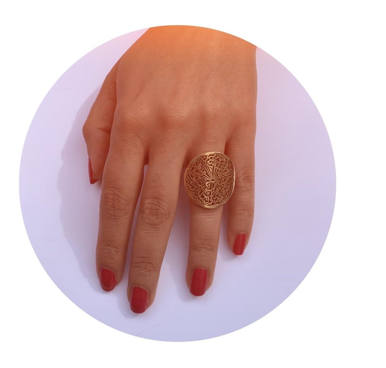 From the Parisa London Collection, this artistically stylised handmade filigree ring is crafted in 18 karat gold with contemporary shiny finish, set intricately with round cut rubies in a bezel type setting on the top of some of the letters. The