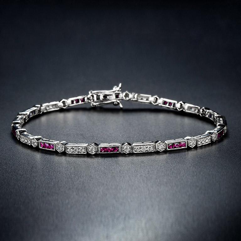 Dieses luxuriöse und farbenfrohe Armband von Aimée ist abwechselnd mit einem Rubin im dreifachen französischen Schliff und runden Diamanten im Brillantschliff besetzt. Das 18-karätige Weißgold verleiht dem klassischen Art-Deco-Stil Sicherheit, und