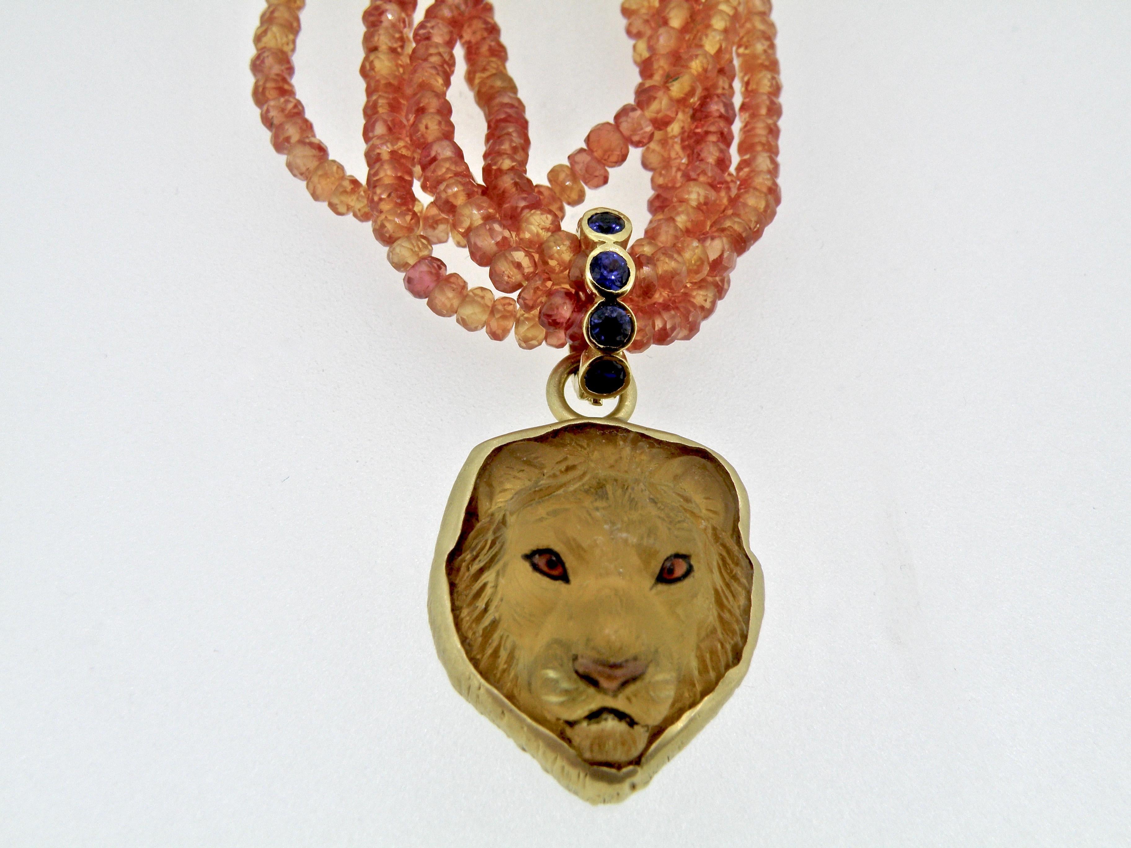 Hand carved Citrine Lionshead with sapphire bail and inlaid jasper nose.