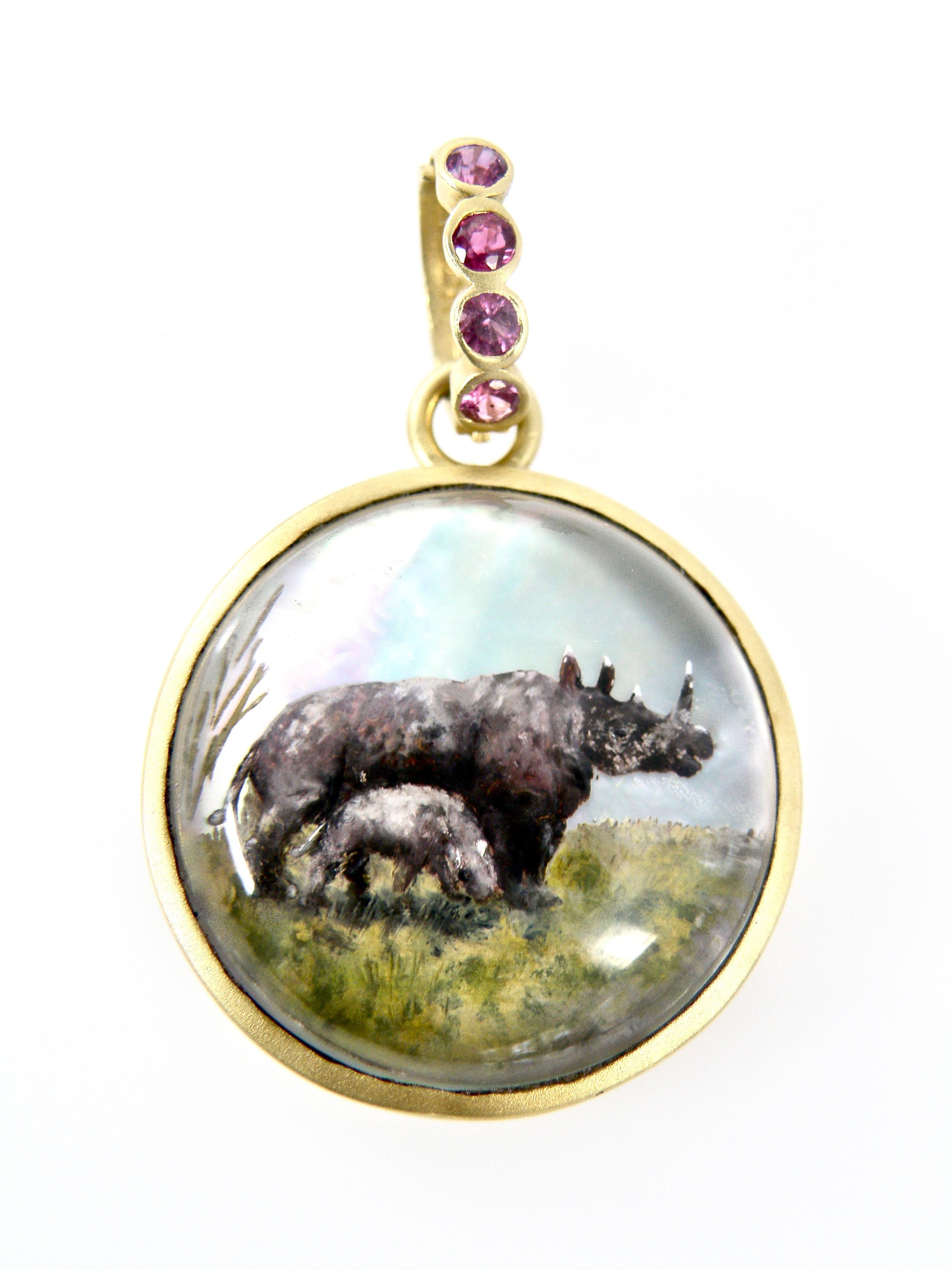 18 karat gold pendant of a Hand painted reverse crystal carving of a Rhinocerous family with a Sapphire bail pendant. Aprox 28 mm round