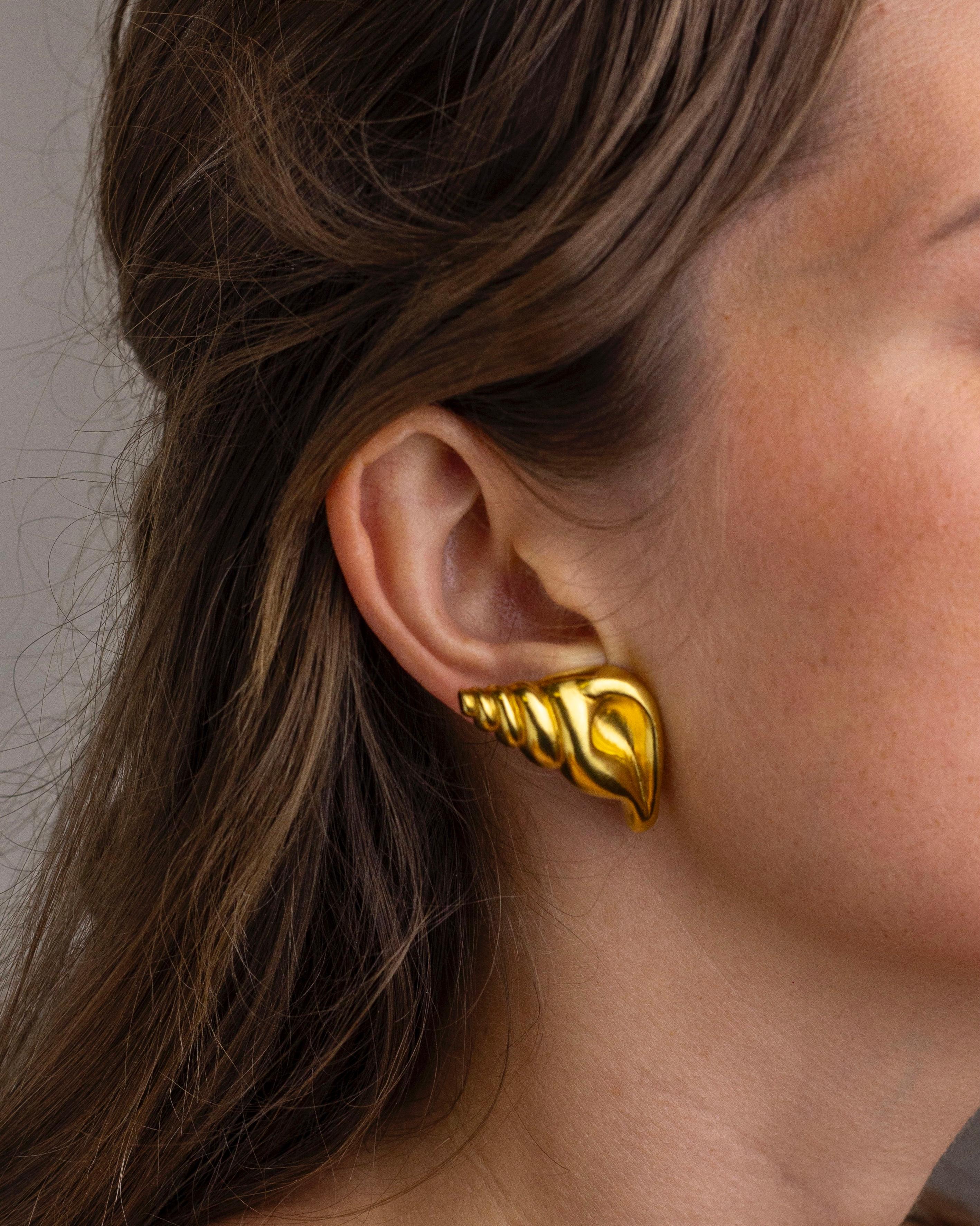 Cette exquise paire de clips d'oreille en or fin a été fabriquée par le joaillier grec Ilias Lalaounis dans les années 1970. Les coquillages stylisés ont été fabriqués en or jaune 18 carats, y compris les attaches qui conservent tous les poinçons de