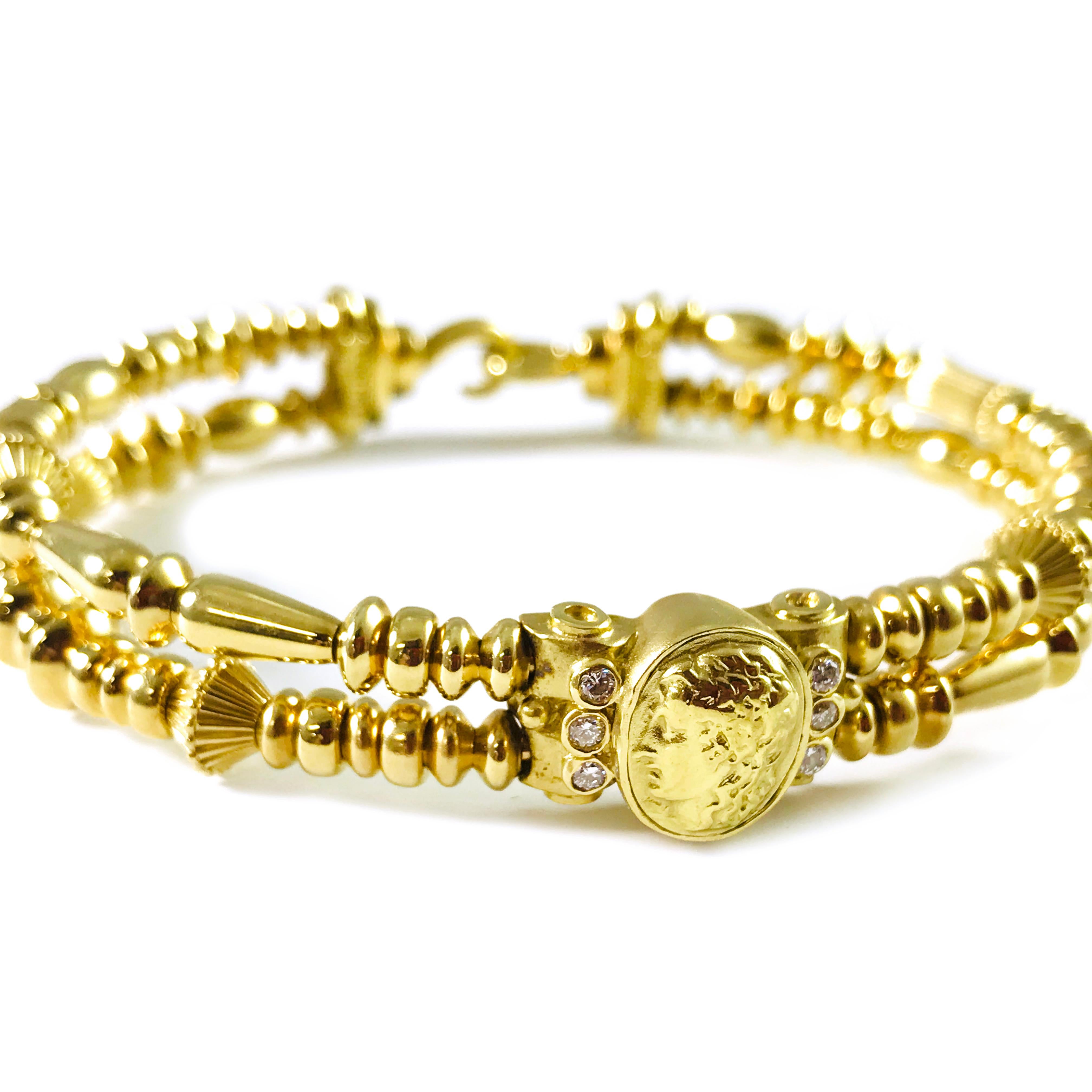 18 Karat Yellow Gold Seidengang Two Strand Bracelet. This lovely bracelet is designed as a double strand of beautiful multi-shaped beads. At the top of the bracelet is the head of Greek God Apollo with three bezel-set round 2mm diamonds along each