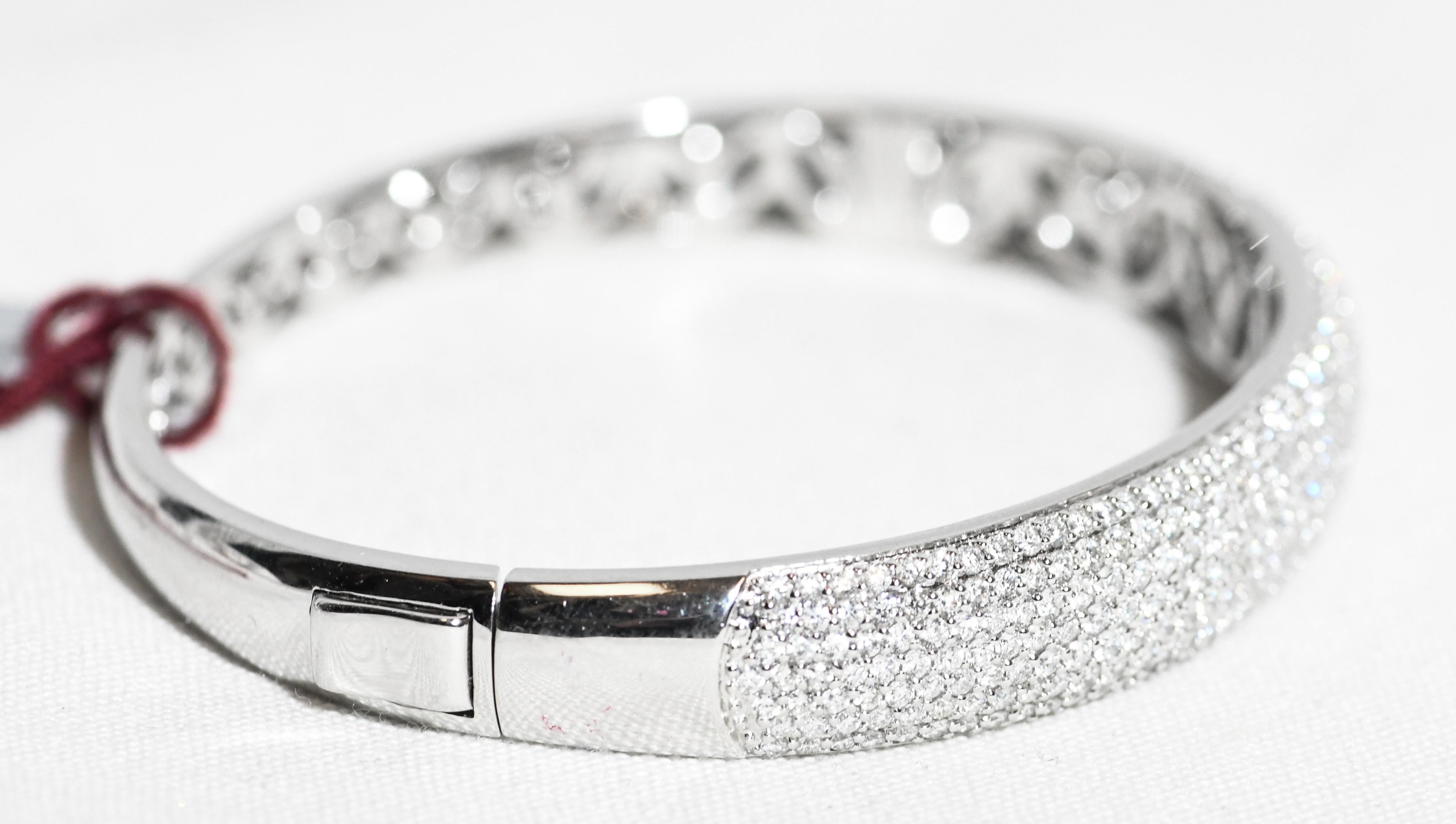 Perfection!  Classic domed top hinged bangle bracelet boasts 321 round white pave diamonds across the top.  Total diamond weight 3.75 carats having G color, VS clarity.  A simple to use push down clasp for ease of wear features two grooves for