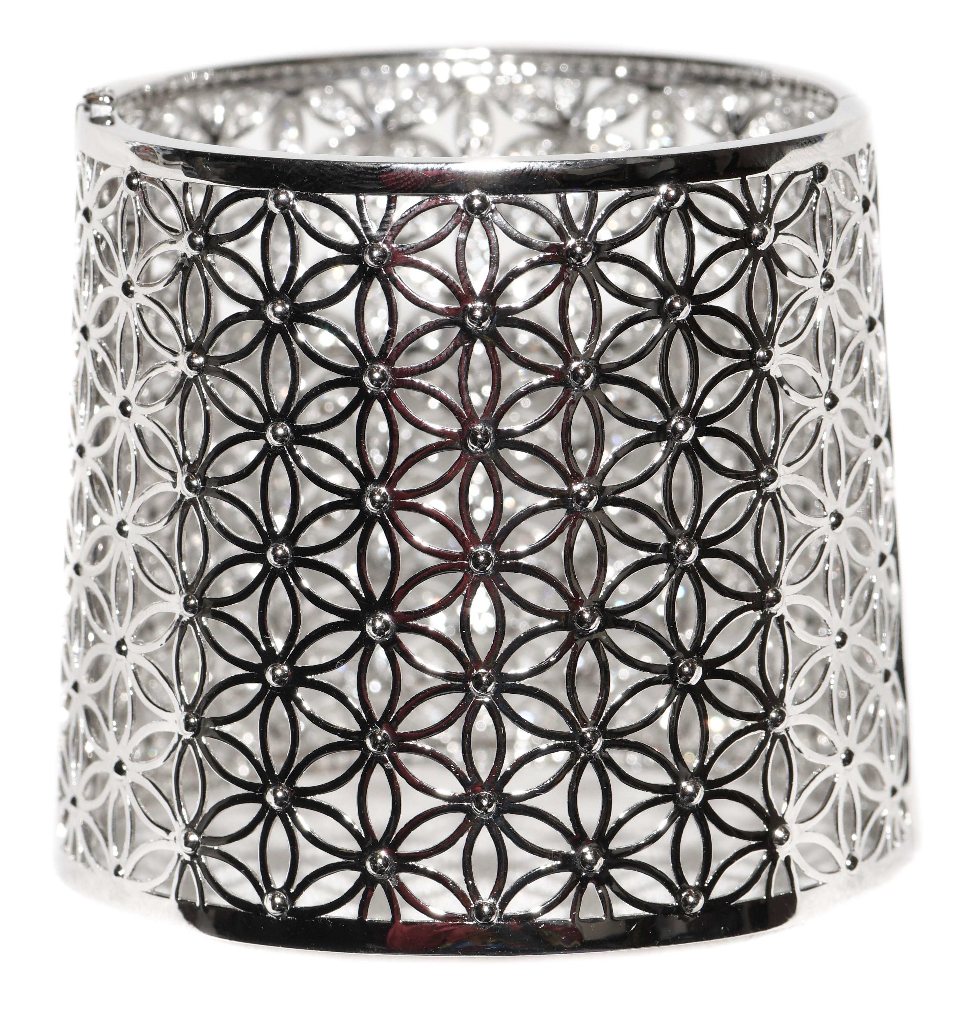 A unique tapered, hinged cuff bracelet exploding with white flower diamonds!  The design genius allows for narrower end to hit the wrist with wider end up farther up the arm for a wonderful fit!  Cuff measures 2.25