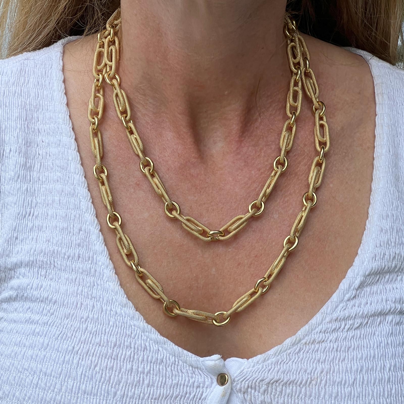 Original paperclip necklace handcrafted in 18 karat textured yellow gold. The necklace features oval textured paperclip links alternating with high polish round links to make this stylish 40 inch necklace. The necklace can be worn long or doubled