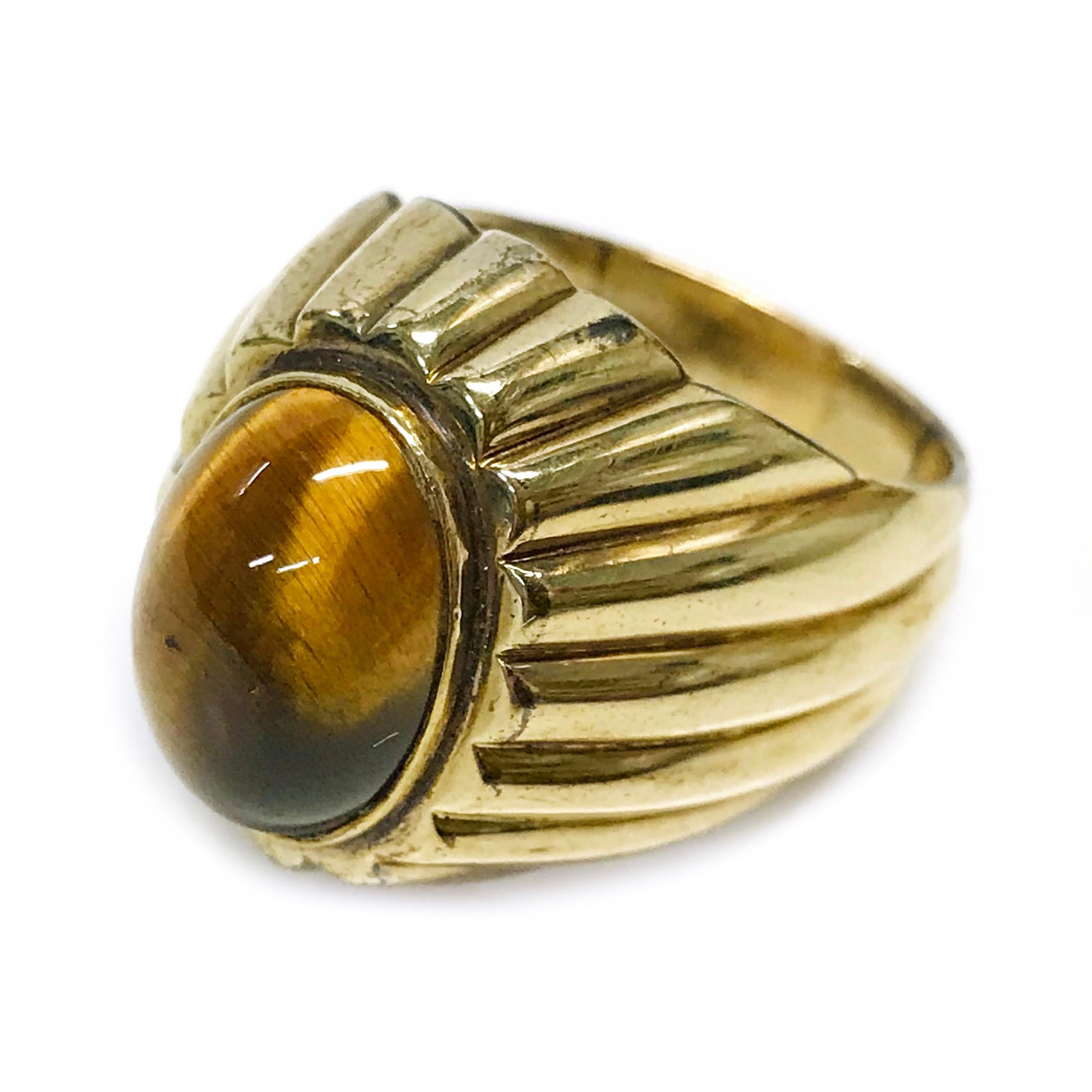 18 Karat Tiger's Eye Ring. The ring features a bezel-set oval Tiger's Eye Stone. The stone measures 14mm x 10mm and the ring size is 9. The entire ring has shiny curved domes around the tapered band. The total gold weight of the ring is 16 grams. 