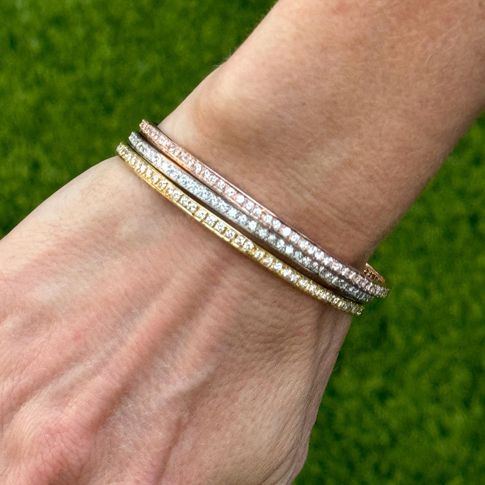 Set of three modern diamond bangle bracelets crafted in 18 karat yellow, white , and rose gold. The bangles are set all the way around with round brilliant cut diamonds weighing 6.30 carat total weight. The diamonds are graded F-H color and VS2-SI1