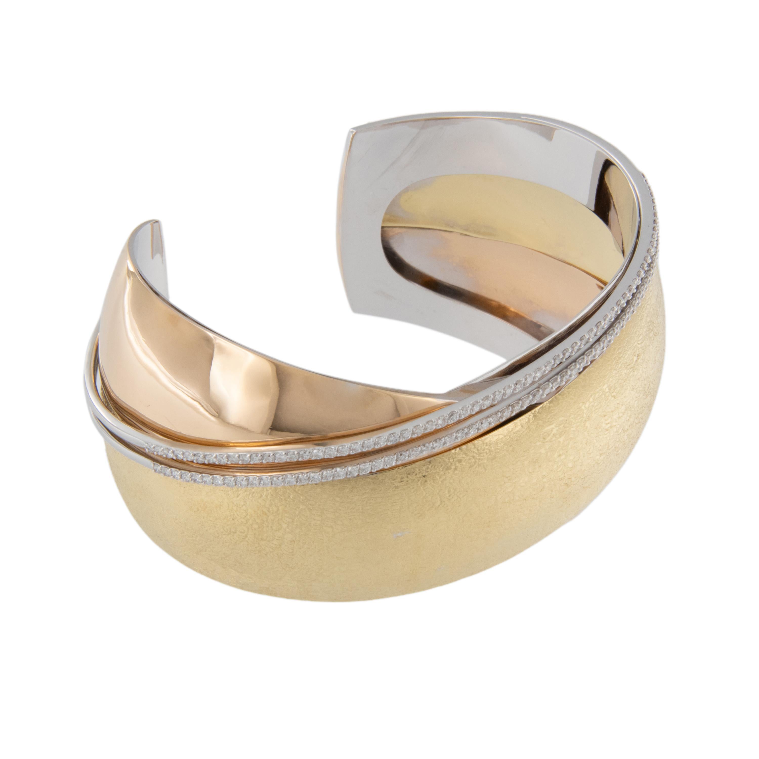 Multi colors and multi textures make this modern crossover designed bracelet stand out from the rest! Made of rich 18 karat yellow gold and convenient cuff design accented with 1.04 Cttw diamonds in 2 rows this bracelet is a knockout! Complimentary