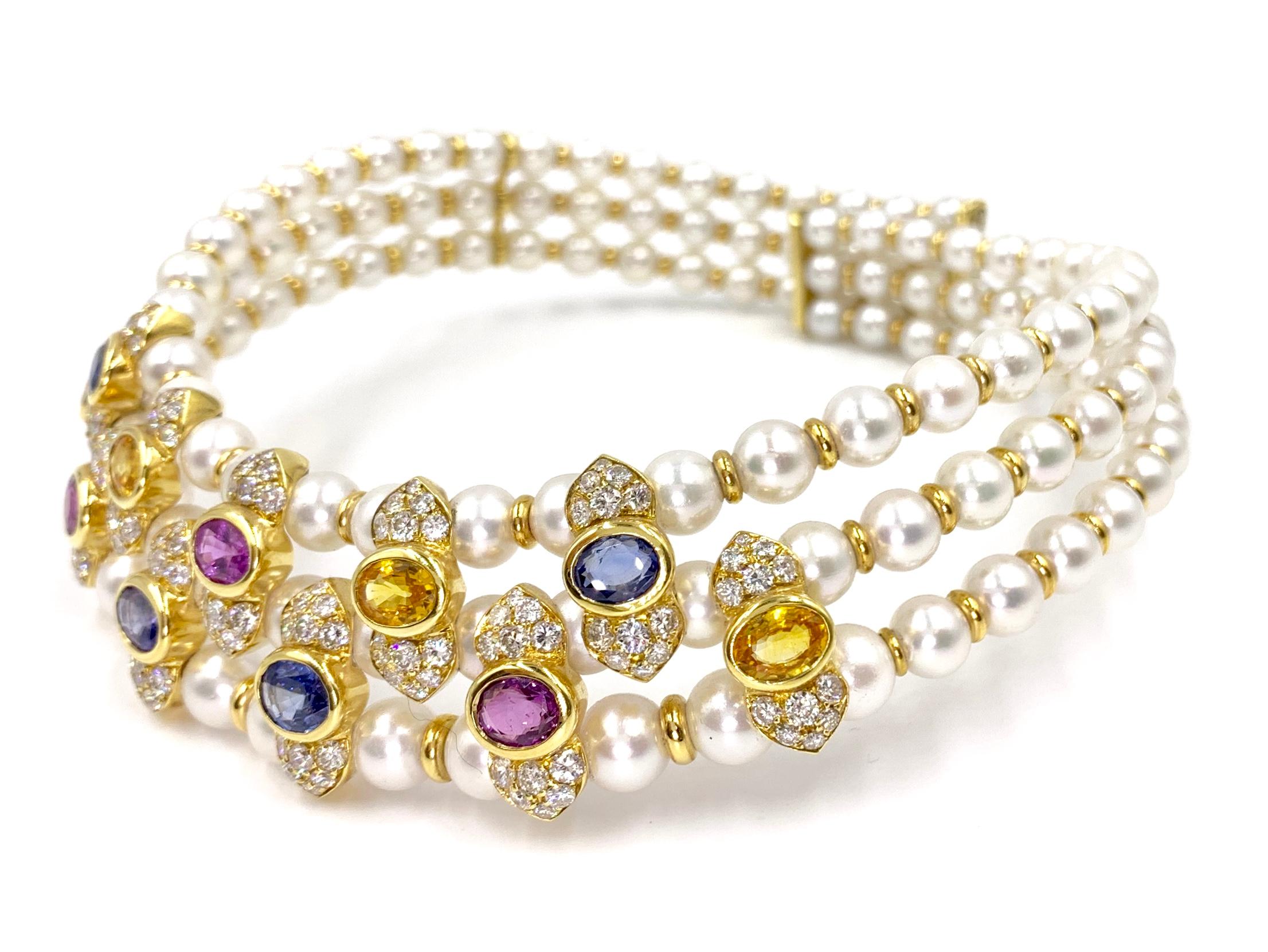 Exceptionally well-made flexible 18 karat yellow gold Victorian inspired choker necklace featuring three rows of lustrous graduated natural pearls, four oval blue sapphires, three oval pink sapphires, four yellow sapphires and white round diamonds.