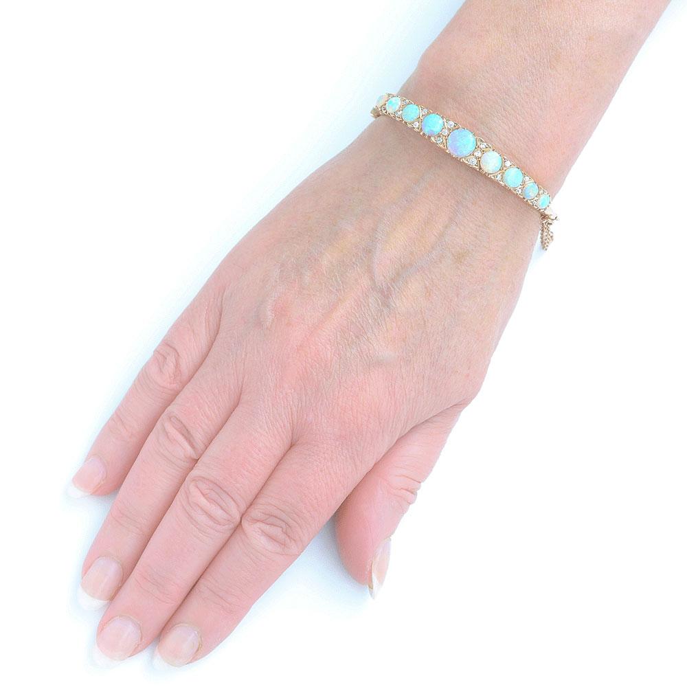 A stunning original antique 18k yellow gold Victorian opal & diamond bangle typical of the design prevalent in the 1880 - 1900 period.

The bangle comprises nine claw set opals with an estimated range of between 2cts and 0.33cts, stones, all of good