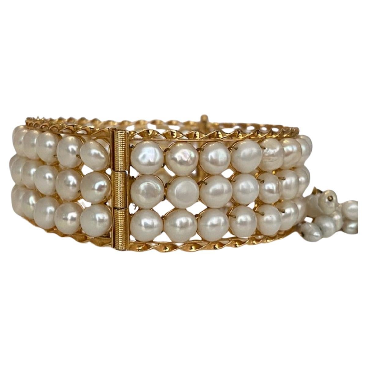 Exclusive 18 kt yellow gold bracelet with 3 rows is provided with 90 natural cultured freshwater pearls and has 18 kt yellow gold clasp set with 15 pieces of baroque pearls. The bracelet is provided with the safe clasp. Gold content: 18 kt