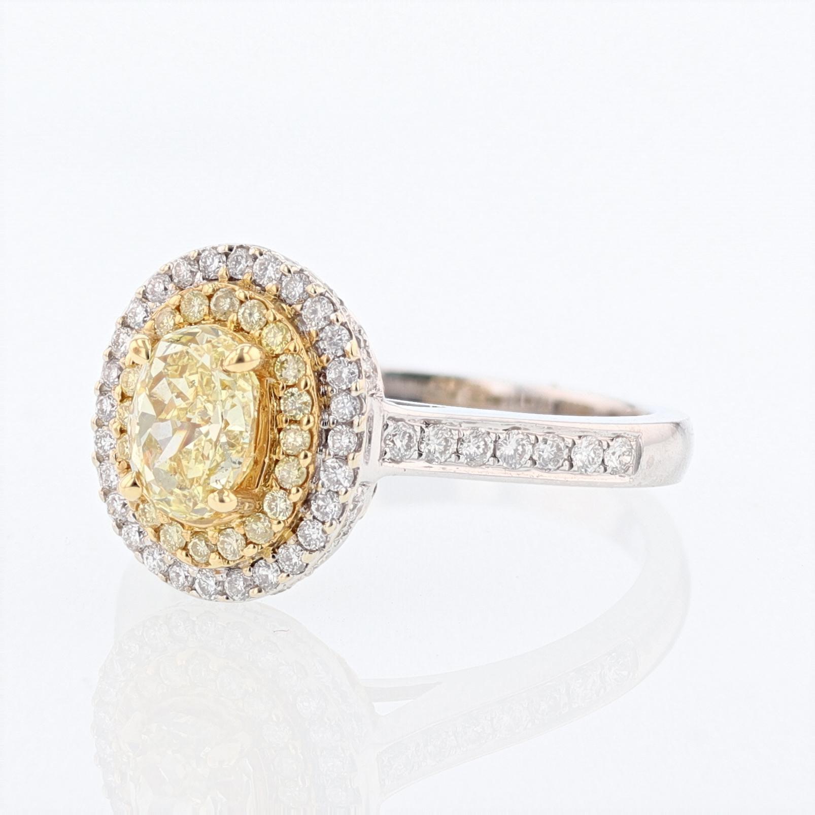 This ring is made in 18 karat white and yellow gold with featuring 
 an oval cut yellow diamond and a double halo with yellow and white diamonds. The center diamond is a 1.01 carat GIA certified  Yellow oval shape diamond with a color grade (FLY, or