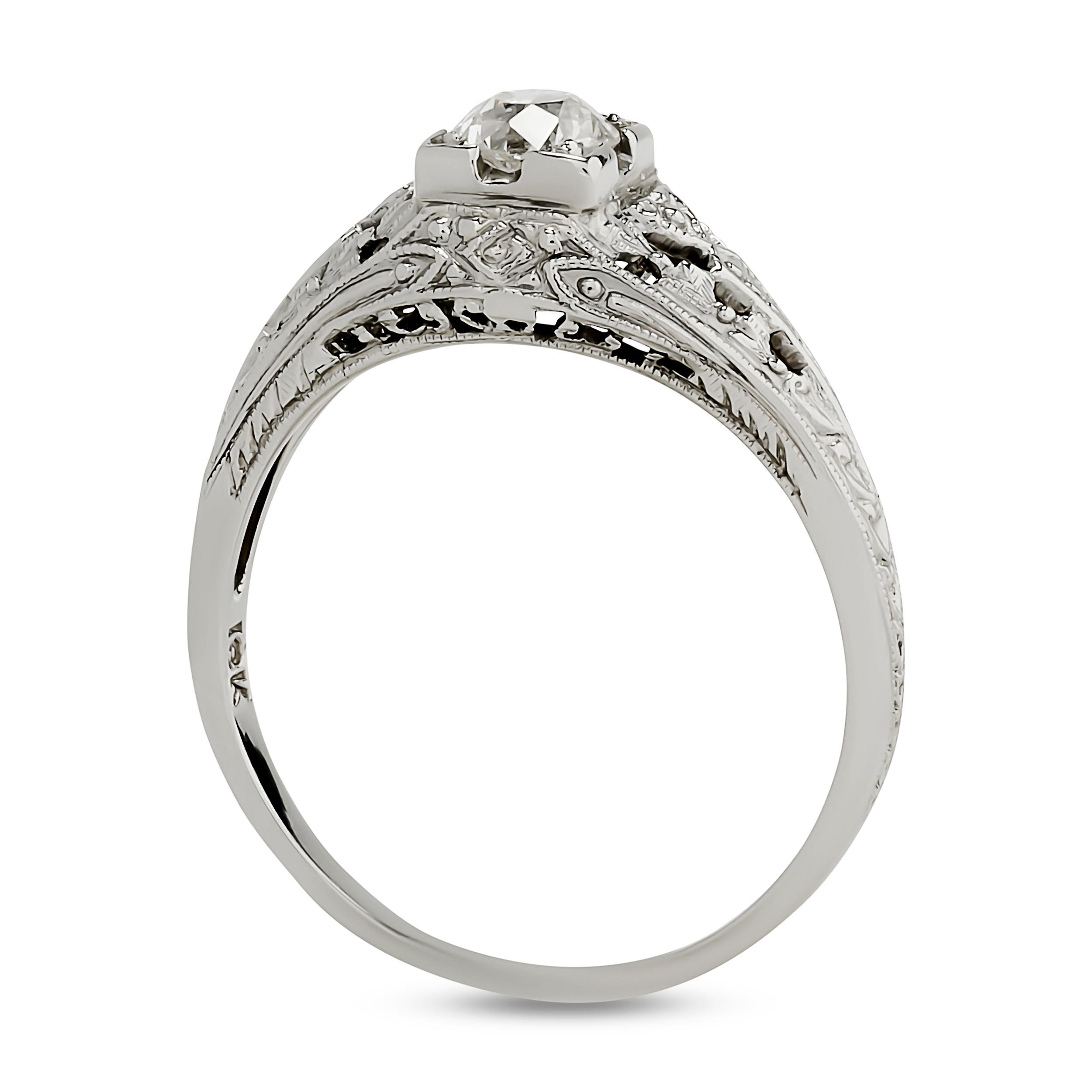 This 18 karat white gold ring features an old European cut diamond set within a square, filigree-detailed frame, further enhanced by intricate openwork and milgrain along the shoulders, reflecting delicate craftsmanship.

Center Old European Cut