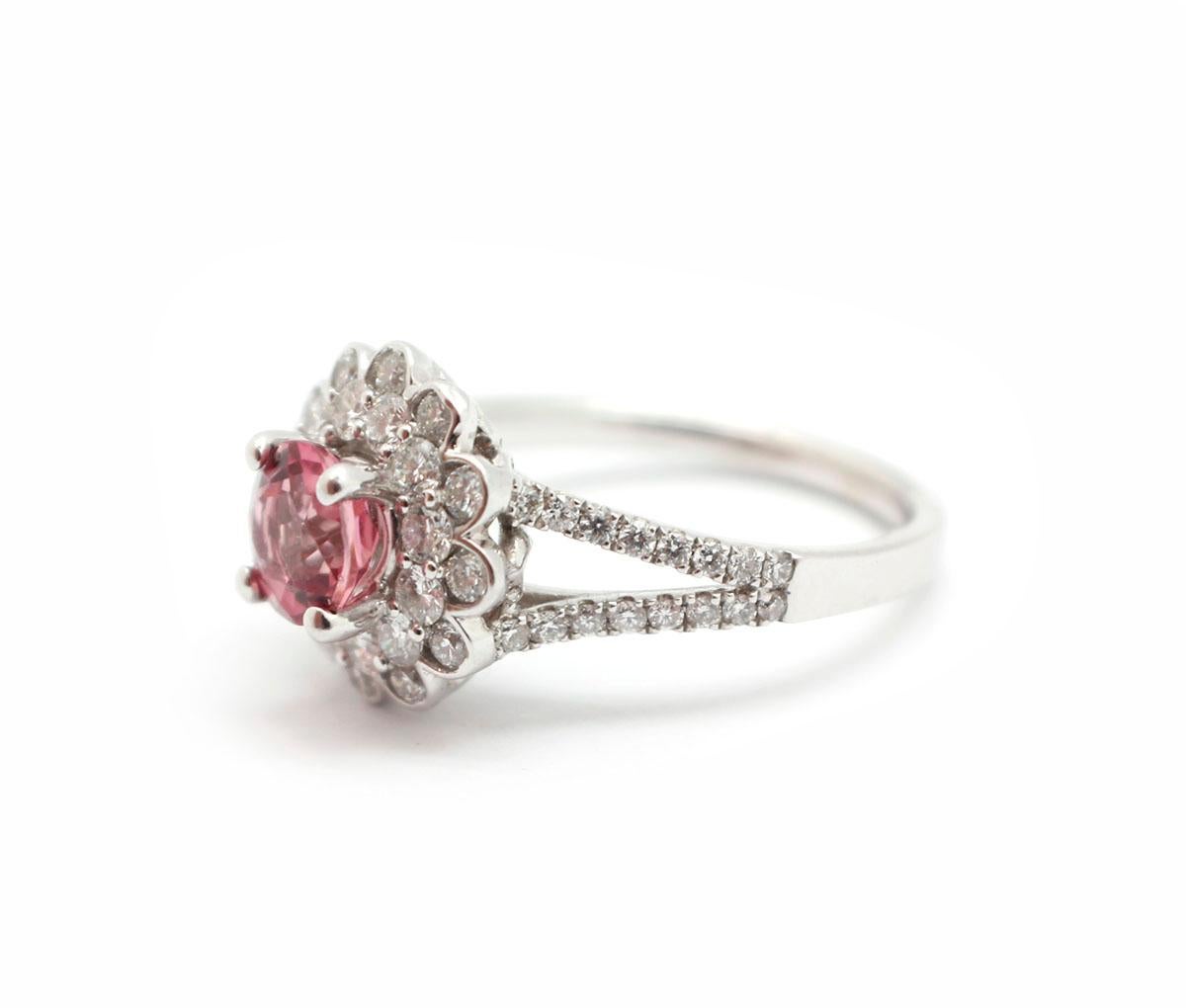 This stunning piece is made in solid 18k white gold. It features a round-cut, 0.50-carat pink tourmaline at its center. The stone is adorned by stunning round brilliant diamonds. The diamonds have an additional weight of 0.84 carat, and they are