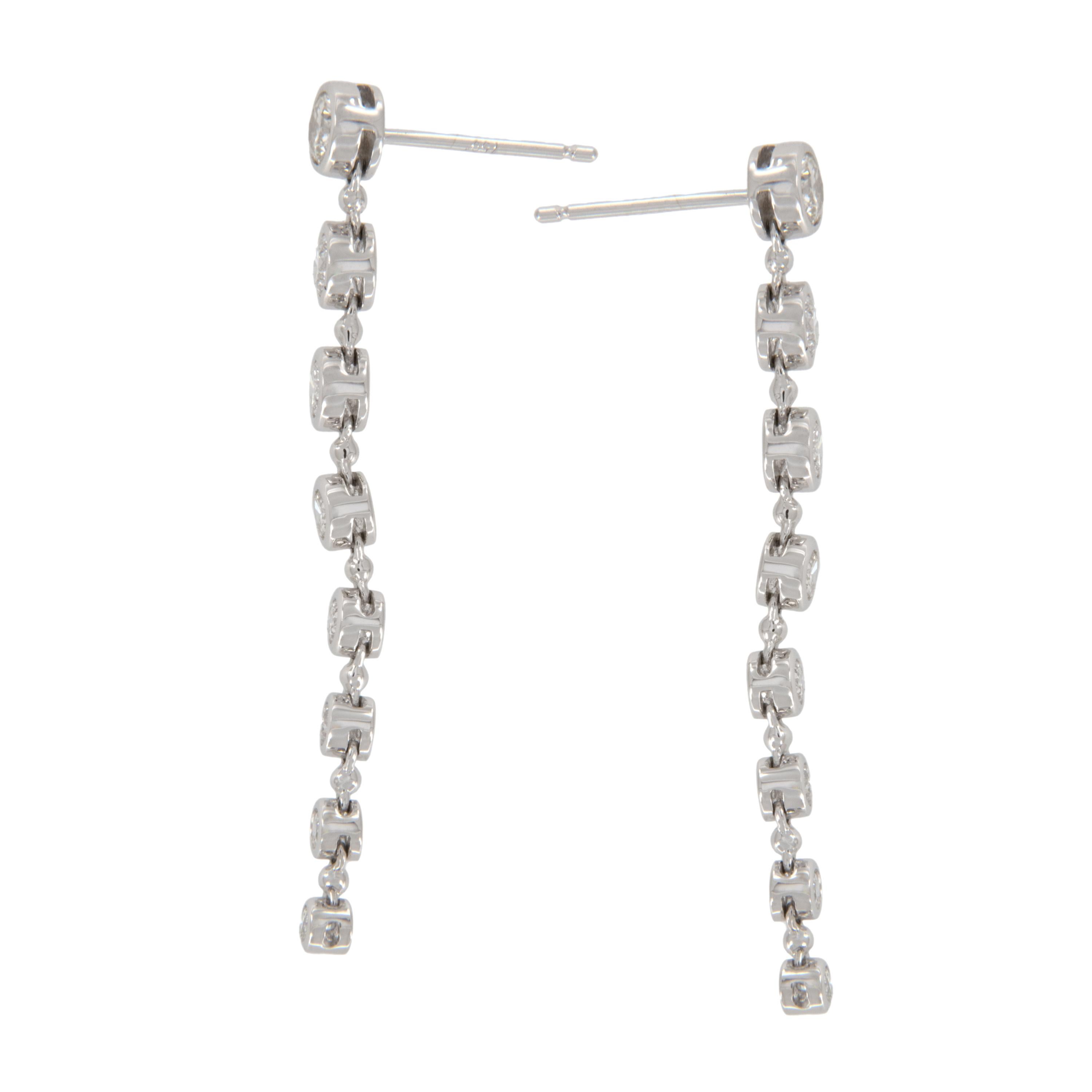 The understated beauty of these breathtaking 18 karat white gold diamond dangle earrings with 16 RBC diamonds = 1.24 Cttw G - VS diamonds bezel set in decrescendo fashion is unsurpassed! Picture perfect being  1-5/8