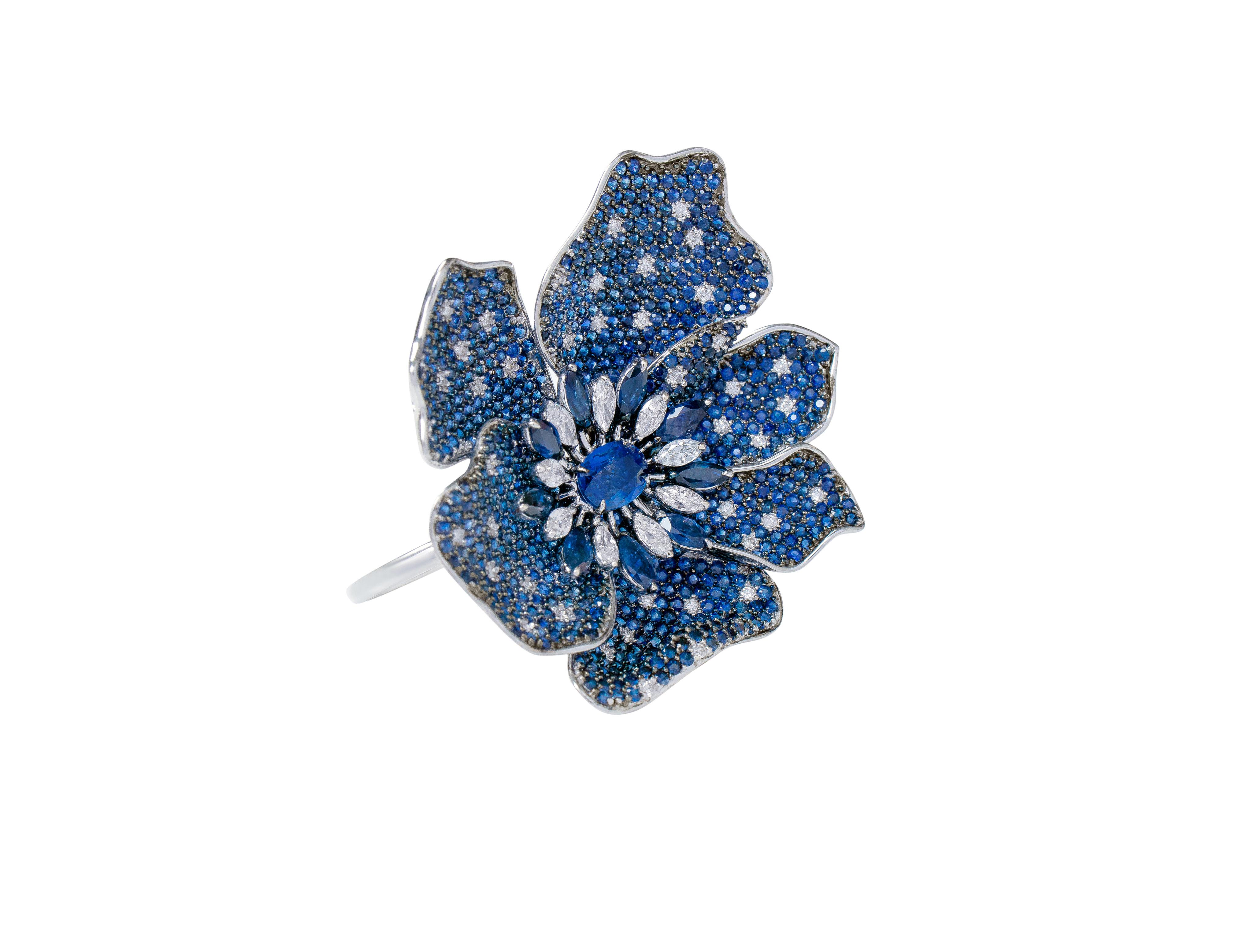 18 Karat White Gold 16.23 Carat Sapphire Flower Two-Finger Statement Ring

This magnanimous cocktail royal blue sapphire ring is a beauty to behold. This design is inspired by our love of nature and flowers with the petals blossoming out to show its