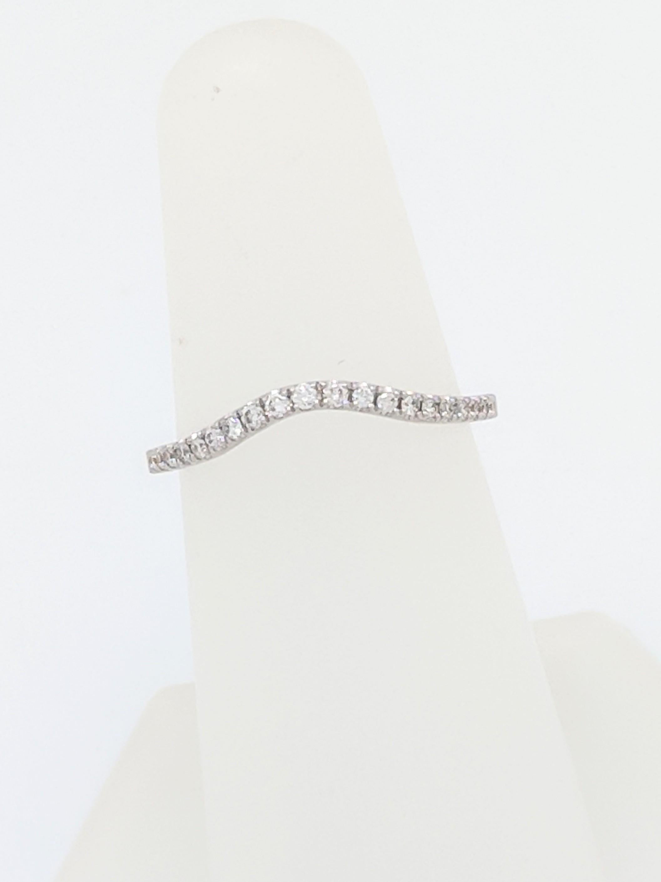 You are viewing a Beautiful Curved Diamond Wedding Band. This band is crafted from 18k white gold and weigh 1.7 grams. This ring features (21) natural round brilliant cut diamonds that are individually prong set for a total carat weight of 0.18