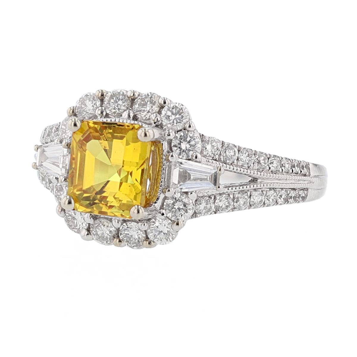 This ring is set in 18 karat white gold. The center stone is an Emerald cut Yellow Sapphire weighing 1.95 carats and is prong set. The Sapphire is AGL Certified (AGL-GB51156). The mounting features 44 round cut diamonds weighing 0.69cts and 2