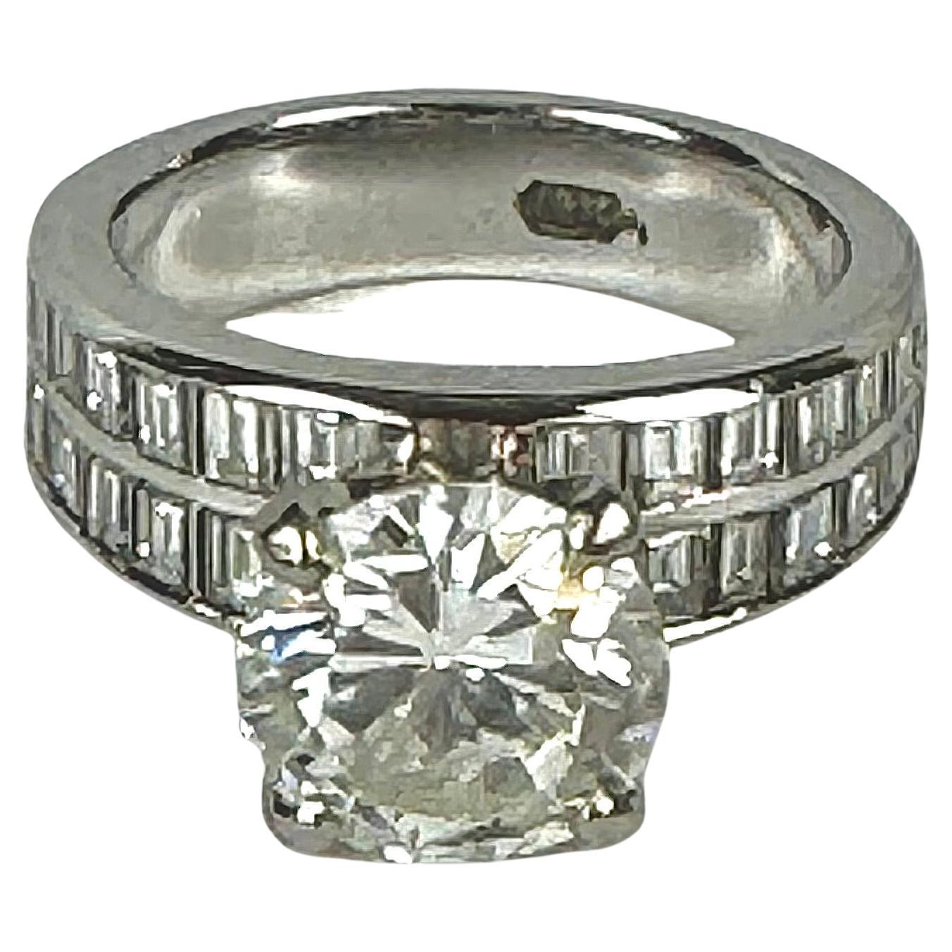 18 Karat White Gold, Diamond Ring
Set with one round brilliant diamond approximate color I, clarity I F weighing approximately 2.62 carats, along with 28 baguette cut diamonds approximate color I, clarity S 12 weighing approximately 1.12 carats;