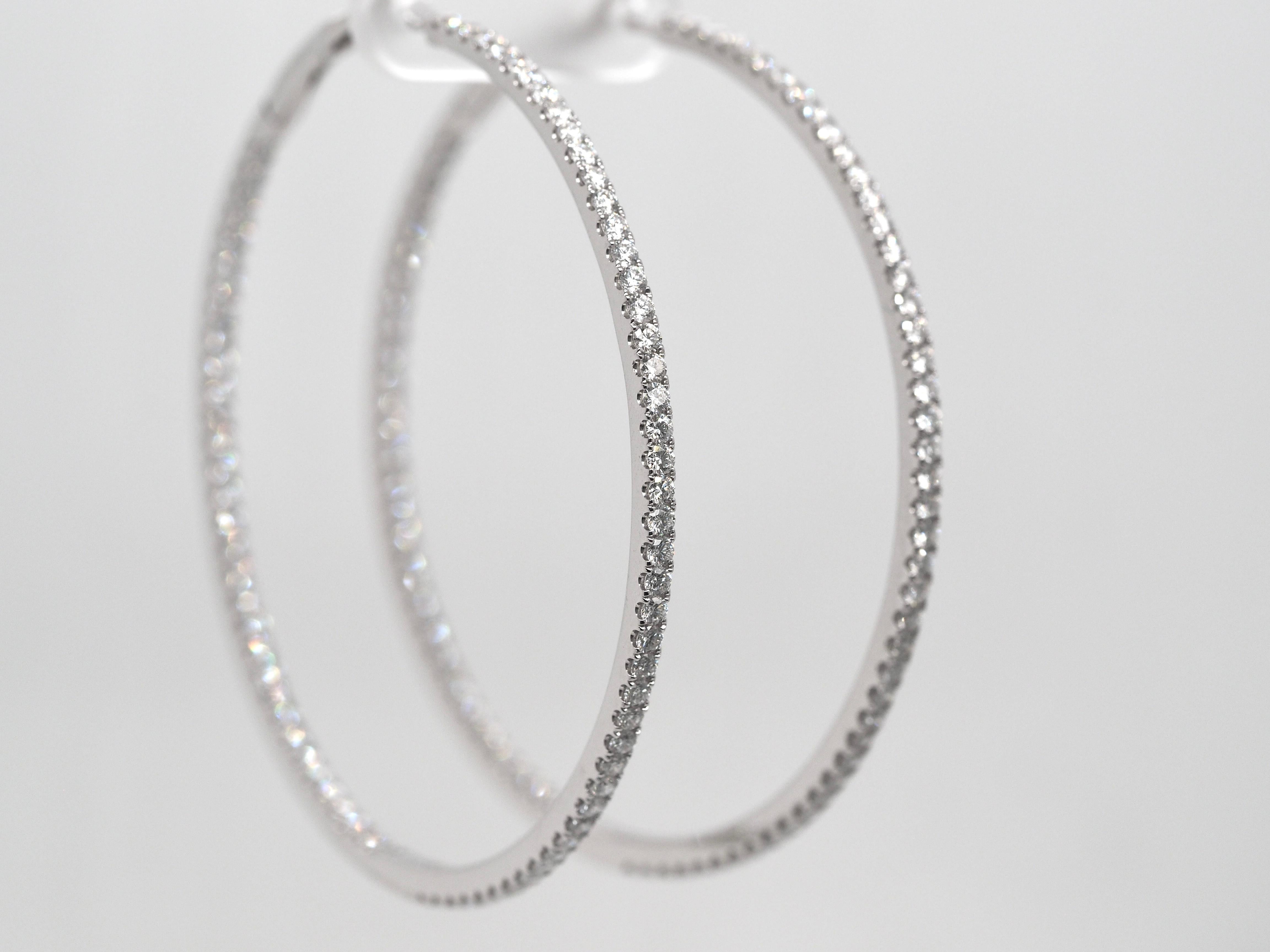 These breathtaking hoop earrings are such a staple piece to anyone's collection. They have incredible round cut diamonds, on the inside and outside, to create an abstract effect, set in 18 karat white gold. They are brand ne earrings, perfect for