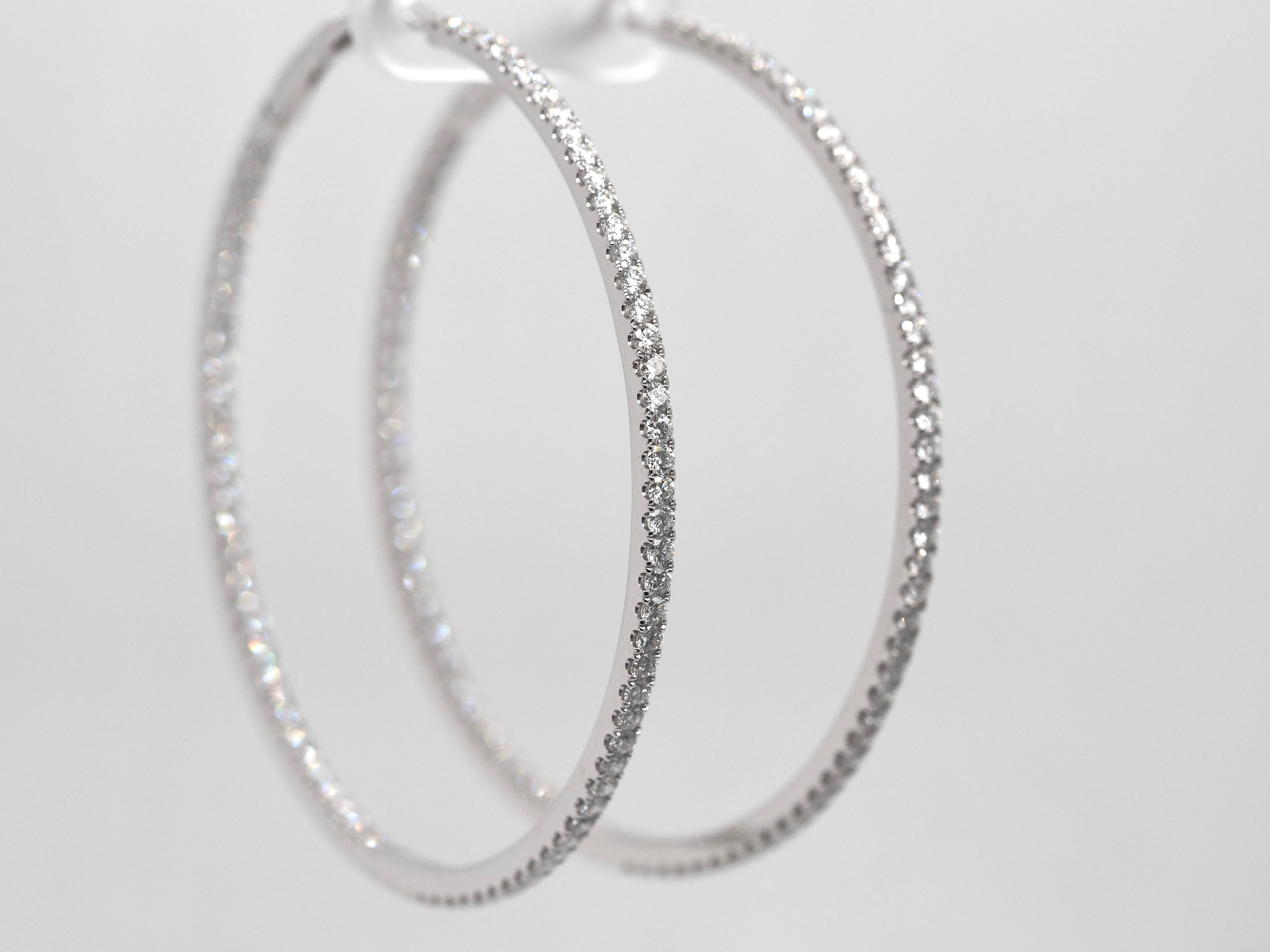 Ces boucles d'oreilles à couper le souffle sont un élément essentiel de la collection de tout un chacun. Elles comportent d'incroyables diamants de taille ronde, à l'intérieur et à l'extérieur, pour créer un effet abstrait, sertis dans de l'or blanc