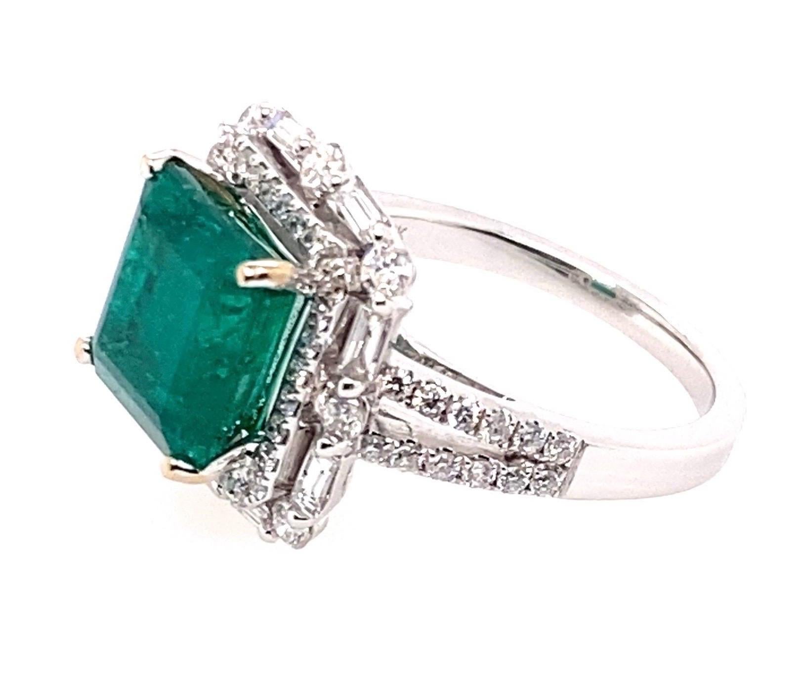 18 Karat White Gold 4.10 Carat Emerald Diamond Cluster Cocktail Ring

Center stone a square emerald set in a four claw setting. There are two rows of diamond surrounding the center stone forming a double cluster head. The emerald sits 8.40mm in