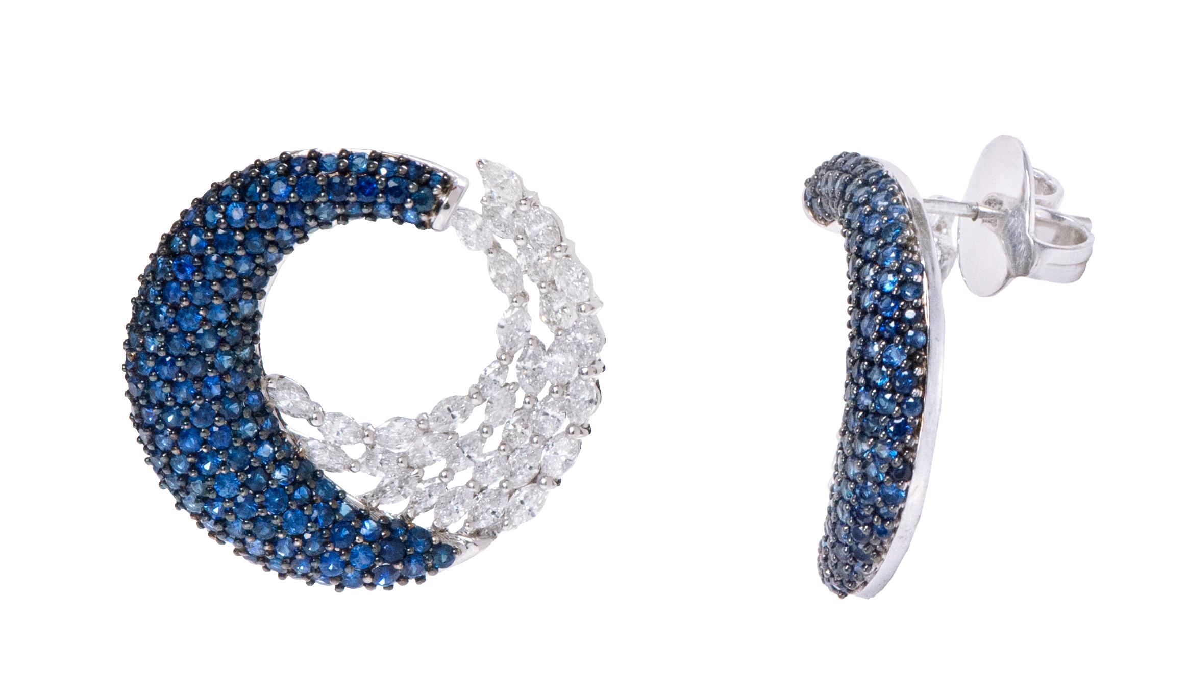 18 Karat White Gold 5.67 Carat Blue Sapphire and Diamond Cocktail Hoop Earrings

This glamorous royal blue sapphire and diamond modern ear hoop earring is truly exceptional. The unique hoop style covering the front, diverges it away from the