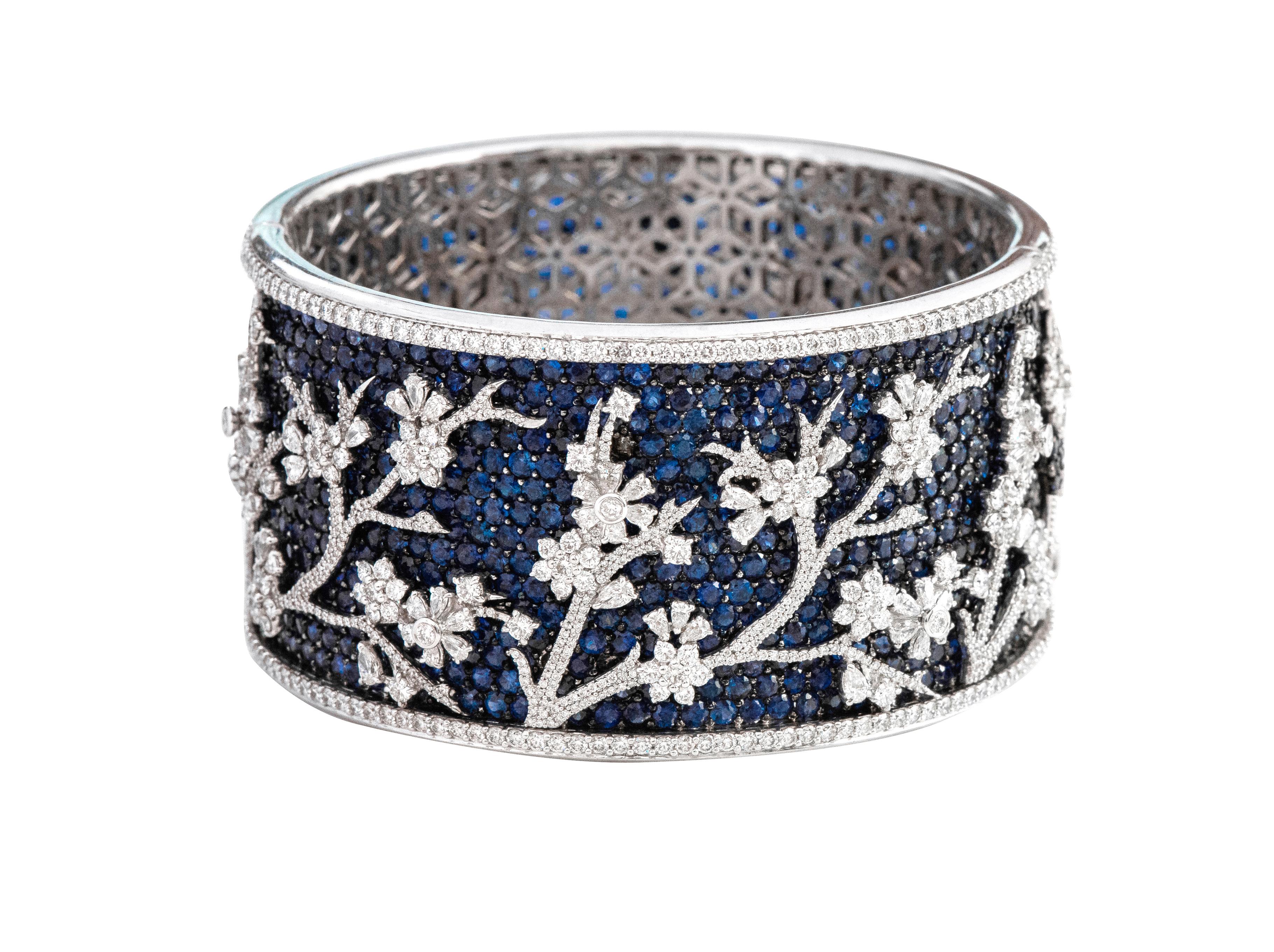 18 Karat White Gold 63.63 Carat Sapphire and Diamond Bangle in Modern Style 

This nouveau riche style royal blue sapphire and diamond bangle is incredibly artisanal. The pave set round blue sapphire forms the majestic base of the bangle with the