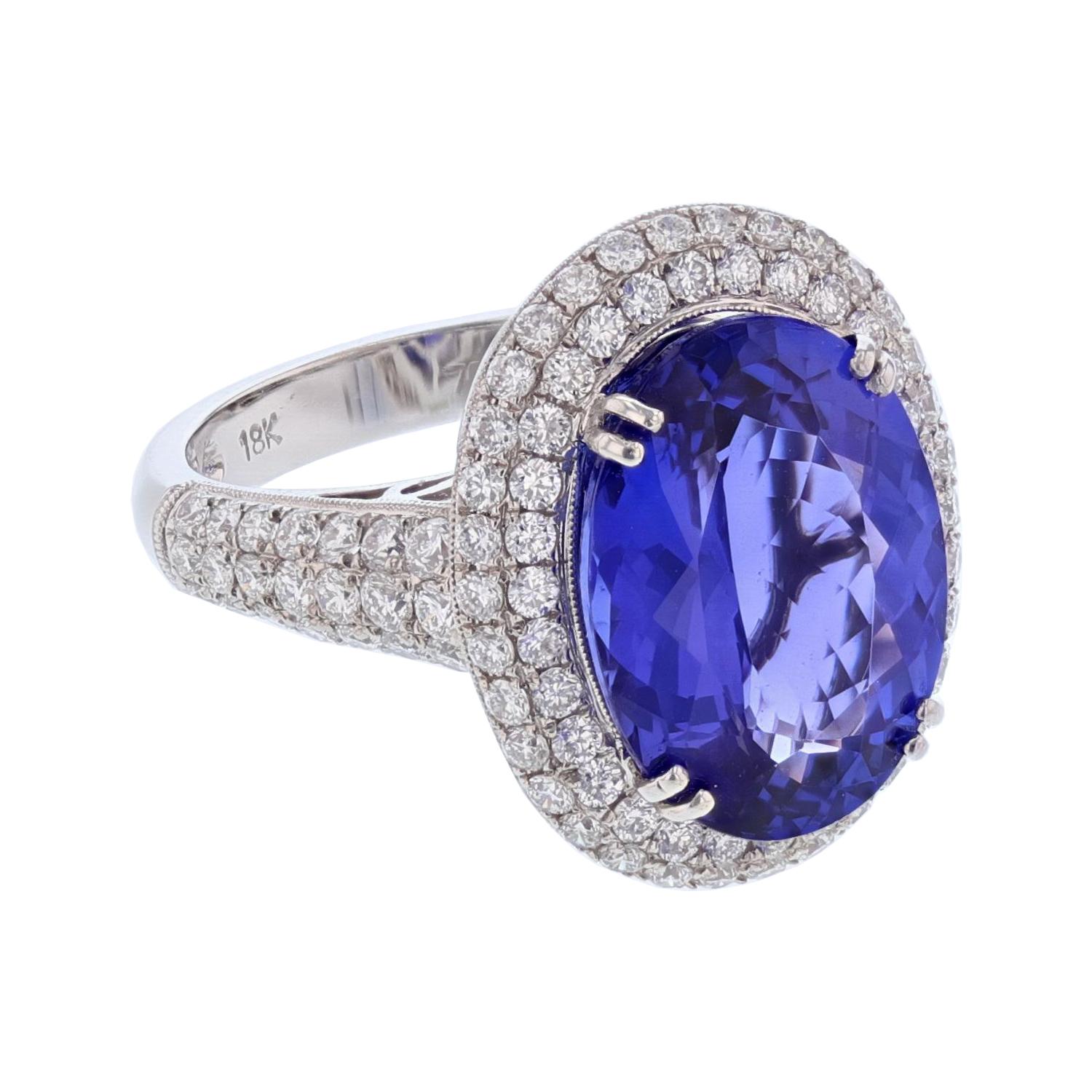This ring is made in 18 karat white gold. The center stone is an oval cut Tanzanite weighing 7.62 carats and is prong set. The mounting features 106 round cut, pave set diamonds weighing 1.52 carats.