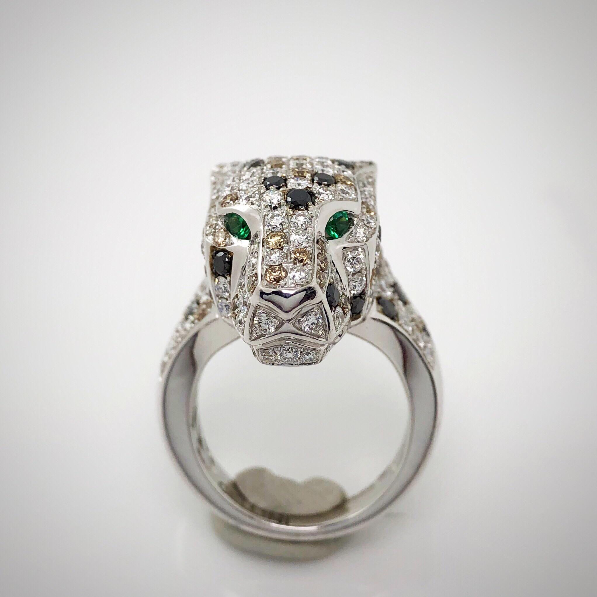 Fun and Fierce describes this panther head ring.  The panther is set with .70 carats of white diamonds, sprinkled with .55 carats of black and brown diamonds. Emerald eyes .06carats.
Ring signes Cellini. 
Ring size 6
Can be sized upon request.