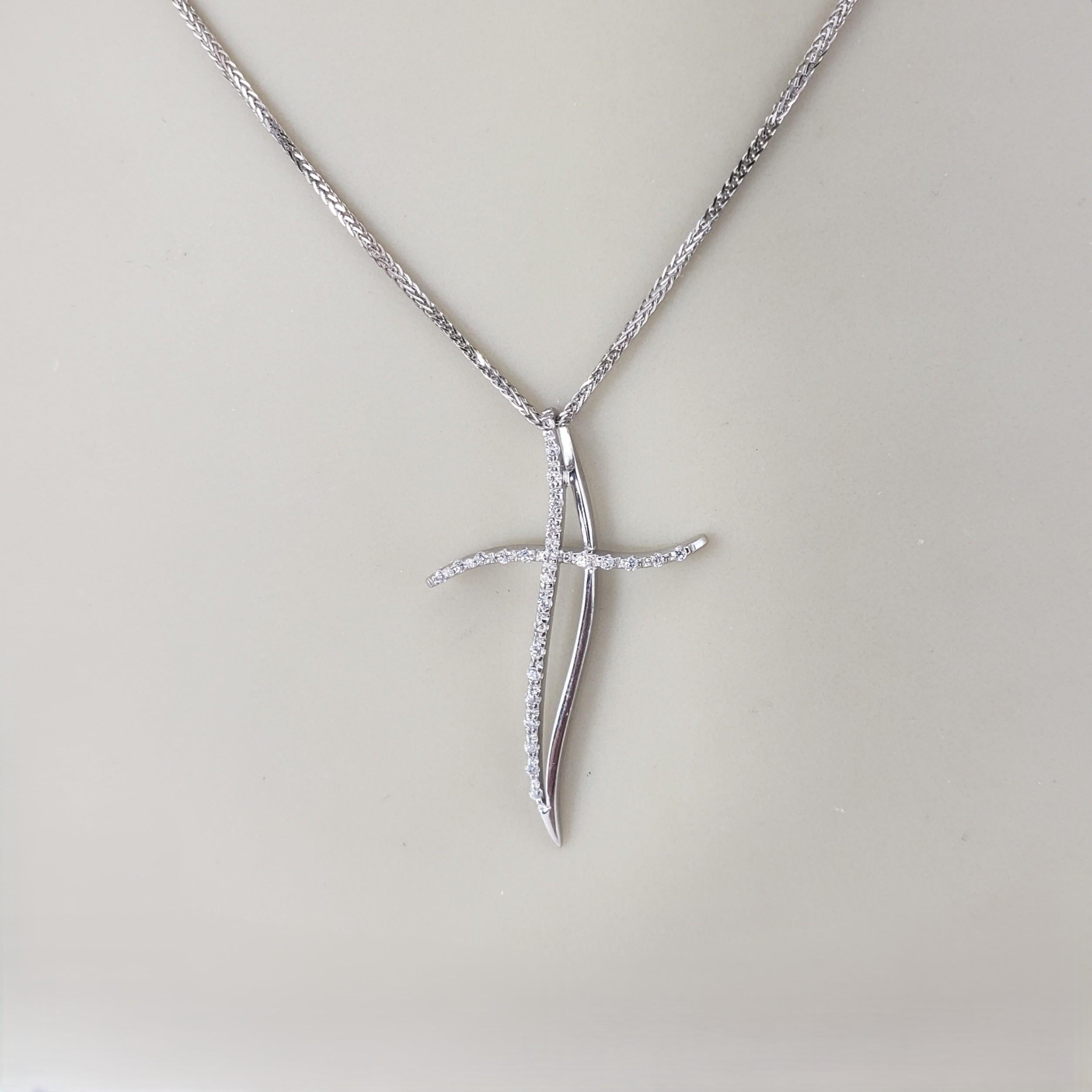 Collana con ciondolo a forma di croce in oro bianco 18 carati e pietre chiare.

Questa elegante collana in oro bianco 18 carati presenta un elegante e contemporaneo ciondolo a forma di croce ricurva con pietre chiare sfaccettate che brillano a ogni